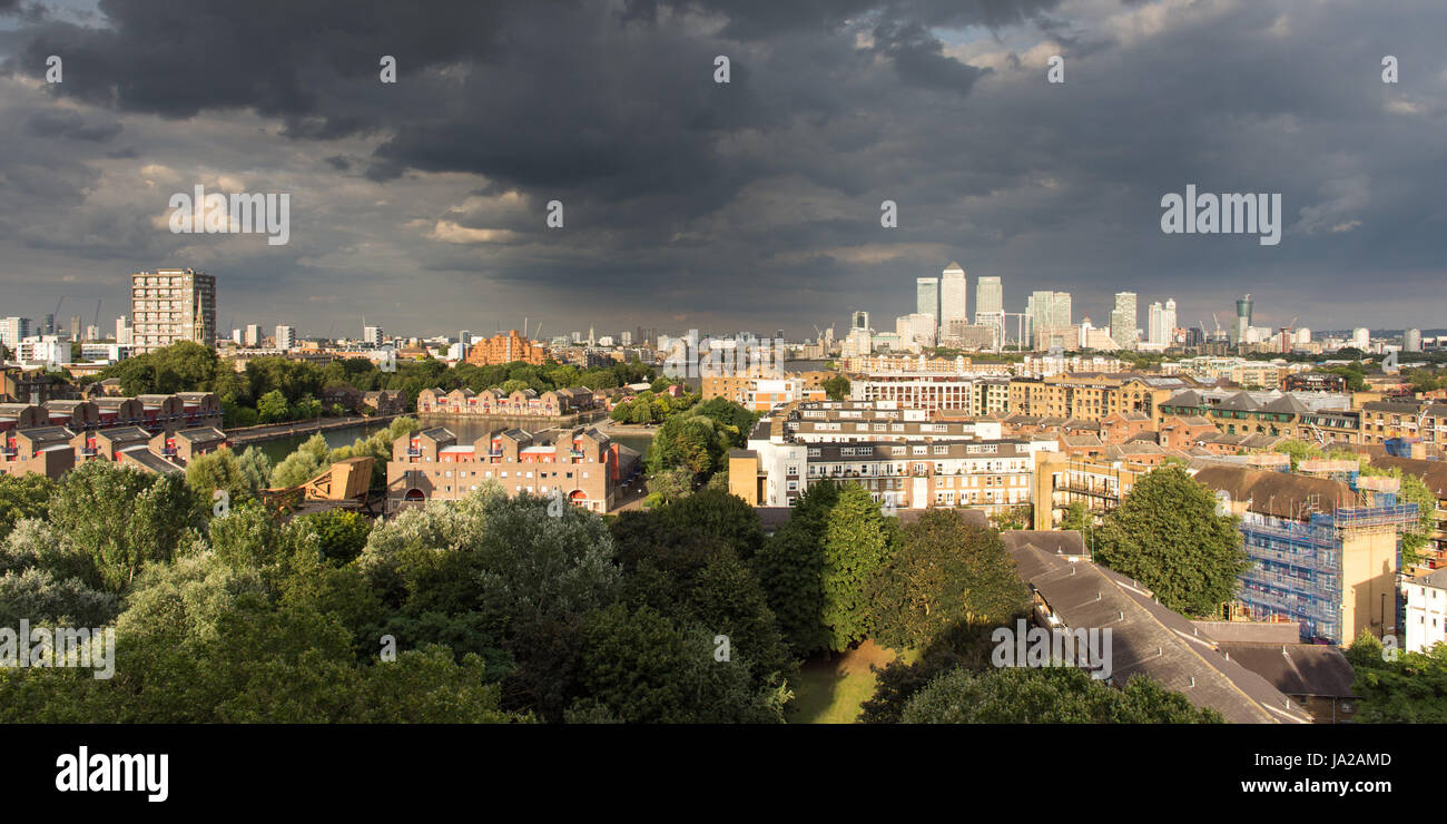 London, England, UK - 5. August 2016: Wolkenkratzer der Londoner Docklands Finanzviertel sind gegen Gewitterwolken beleuchtet. Stockfoto