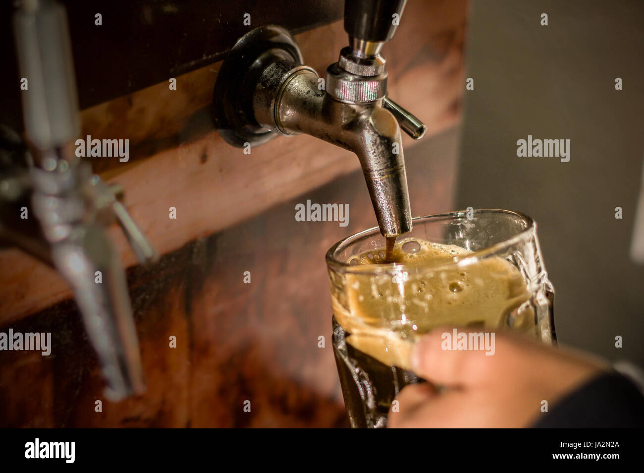 Barkeeper füllt sich mit Handwerk Bier ein Pint Glas Stockfoto
