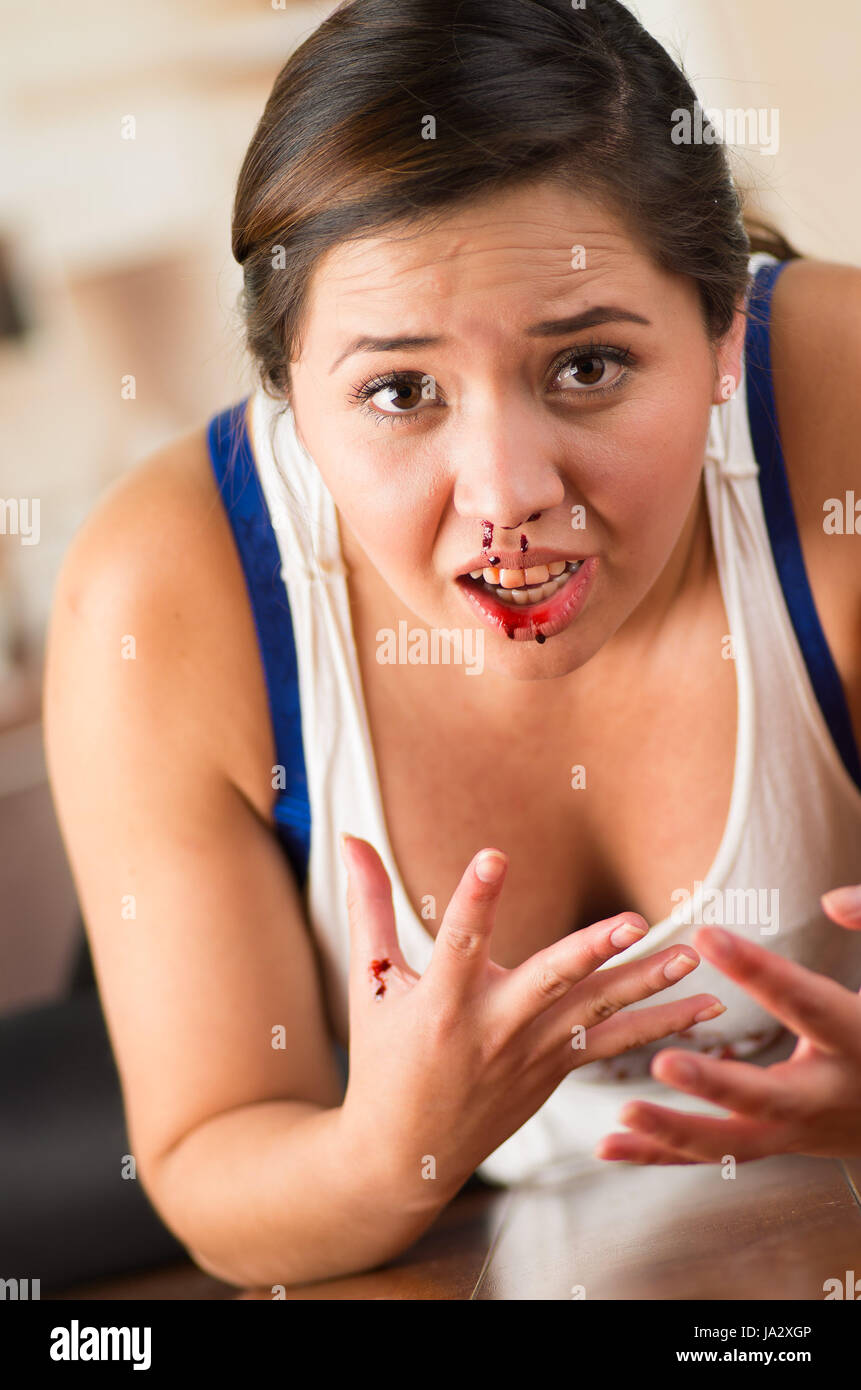 Schöne Frau Nasenbluten, Frau blutet aus der Nase auf Holzboden Stockfoto