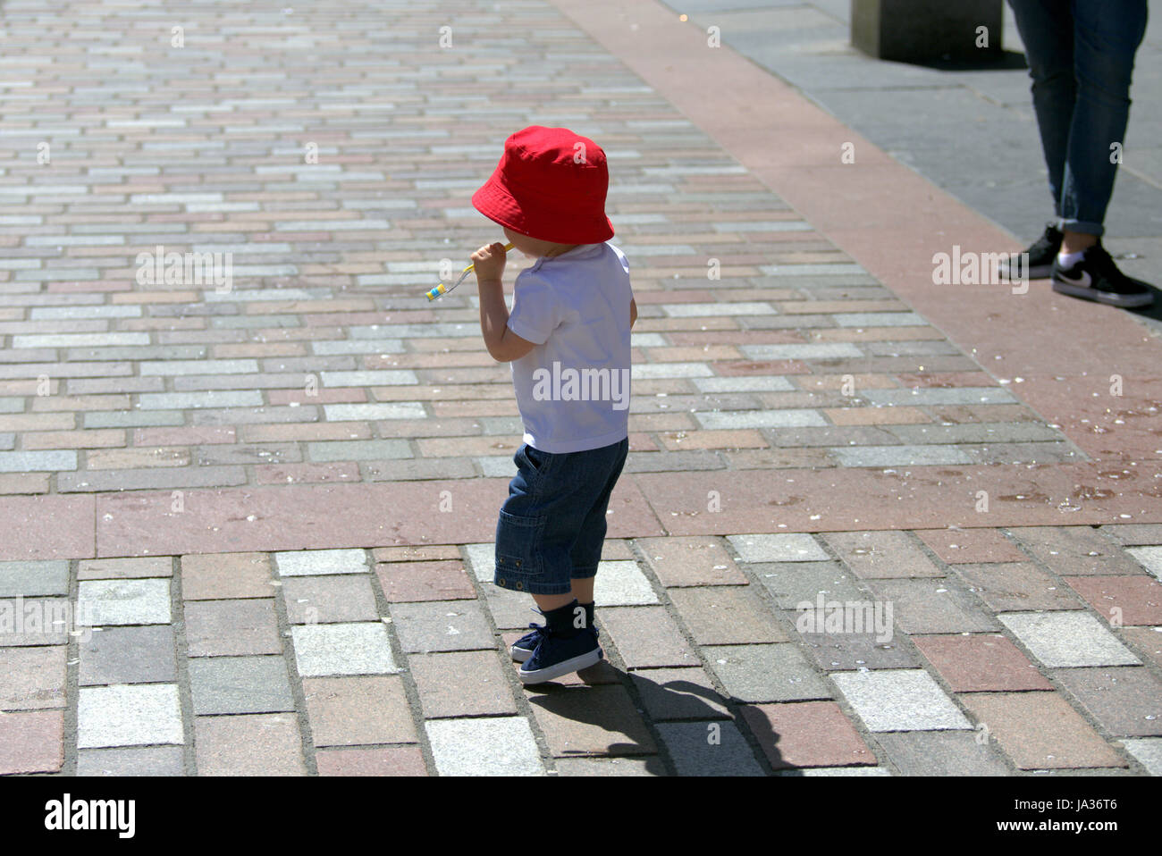 kleiner Junge im roten Hut Sonnentag Stockfoto