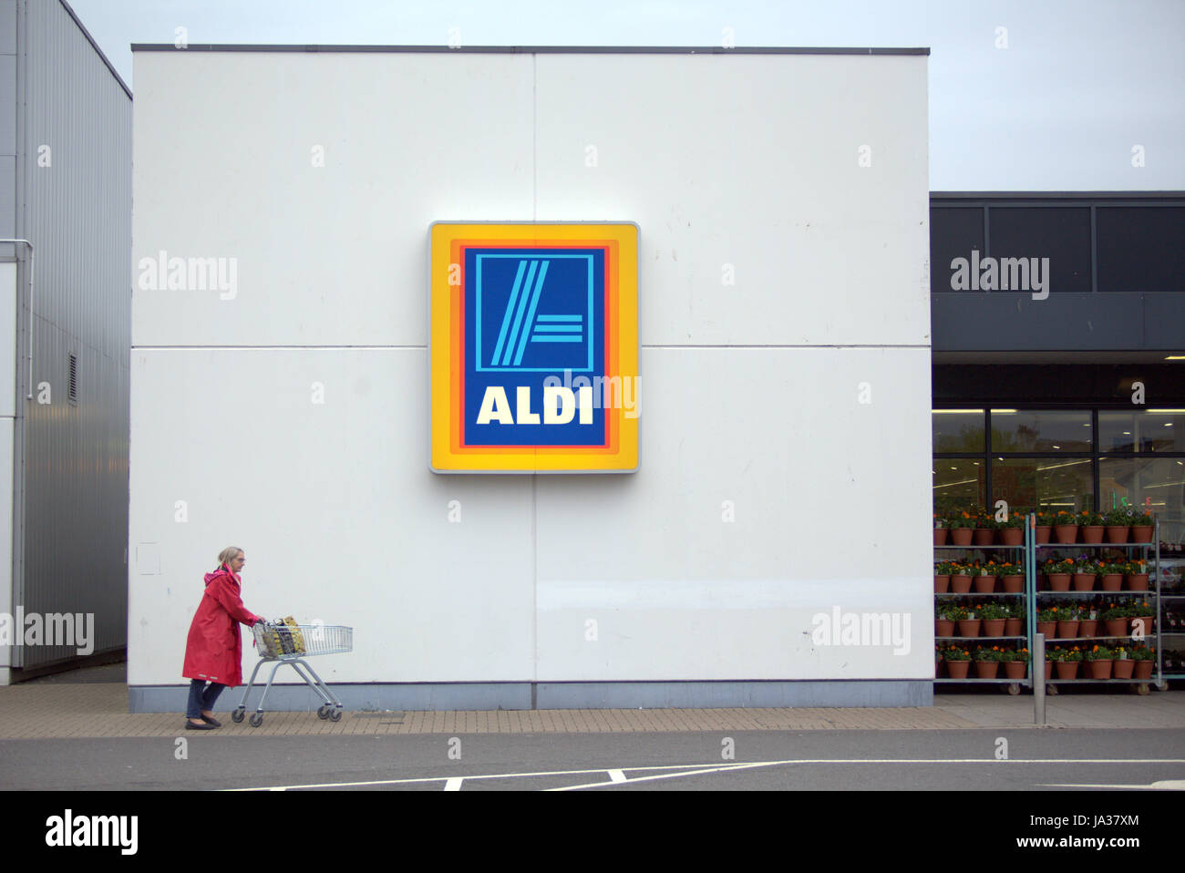 Aldi Supermarkt Logo mit Kunden zu Fuß durch Stockfoto