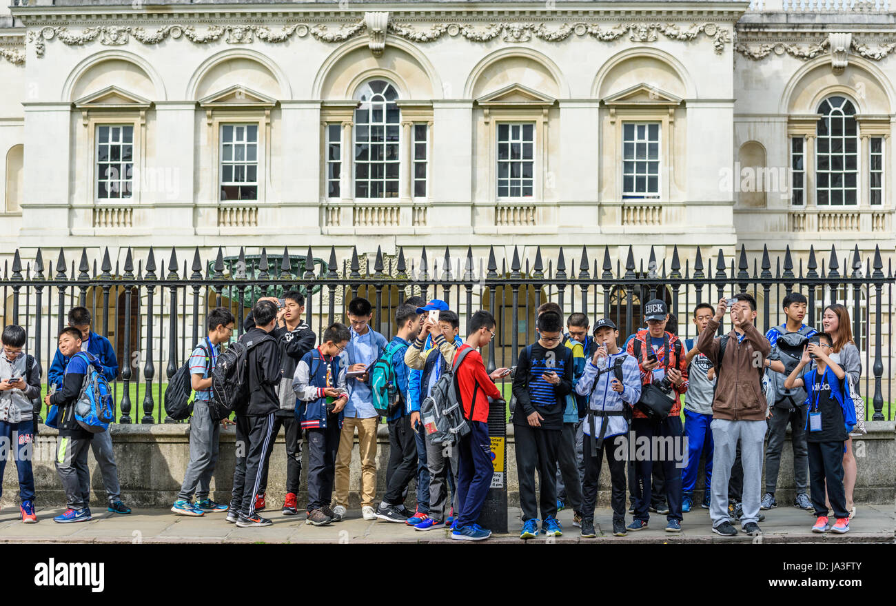 Eine Gruppe von jungen chinesischen Studenten vor dem Geländer vor Senat-Haus, Universität Cambridge, England. Stockfoto