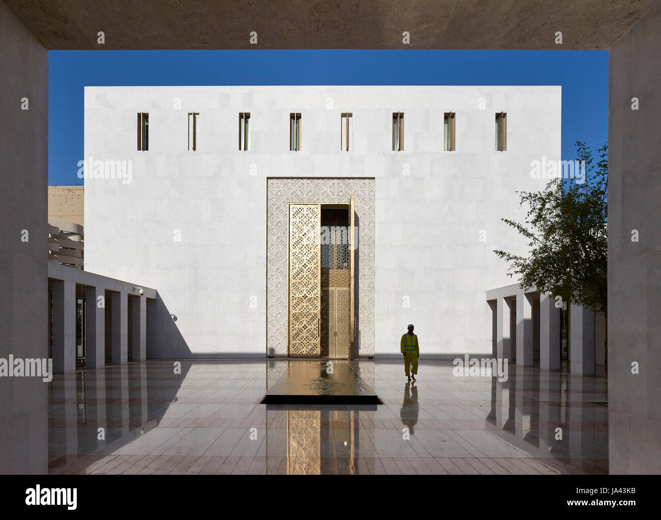 Am frühen Morgen Ansicht mit einsame Figur und Eingang. Jumaa Moschee, Doha, Vereinigte Arabische Emirate. Architekt: John McAslan & Partner, 2017. Stockfoto