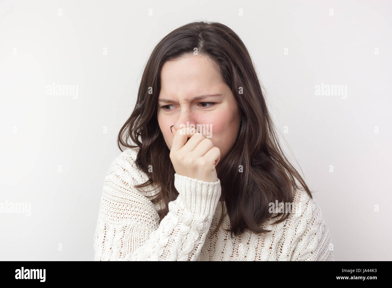 Mädchen mit langen Haaren steckt ihre Nase wegen widerlichen Geruch Stockfoto