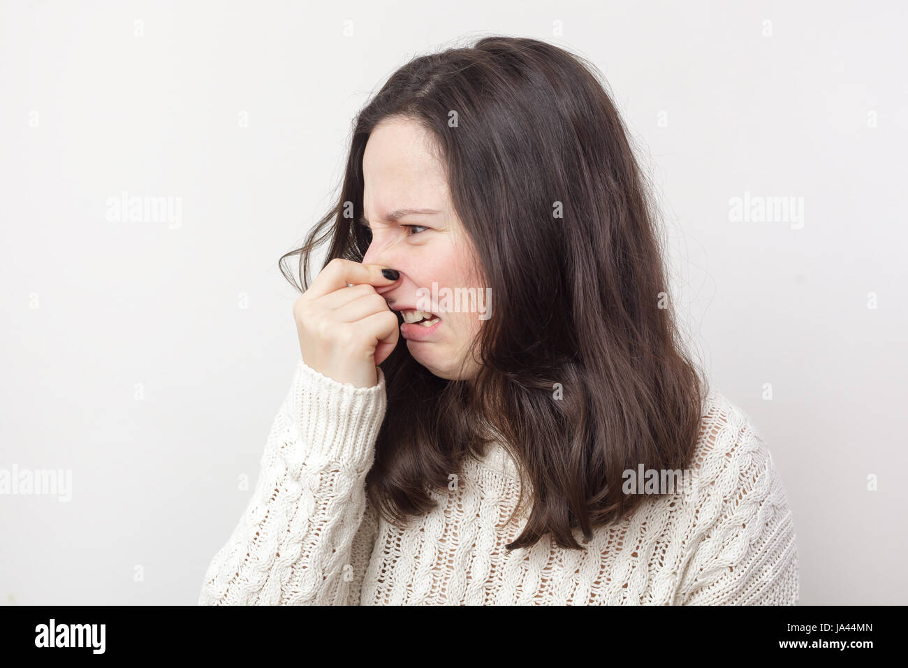 Mädchen mit langen Haaren steckt ihre Nase wegen widerlichen Geruch Stockfoto