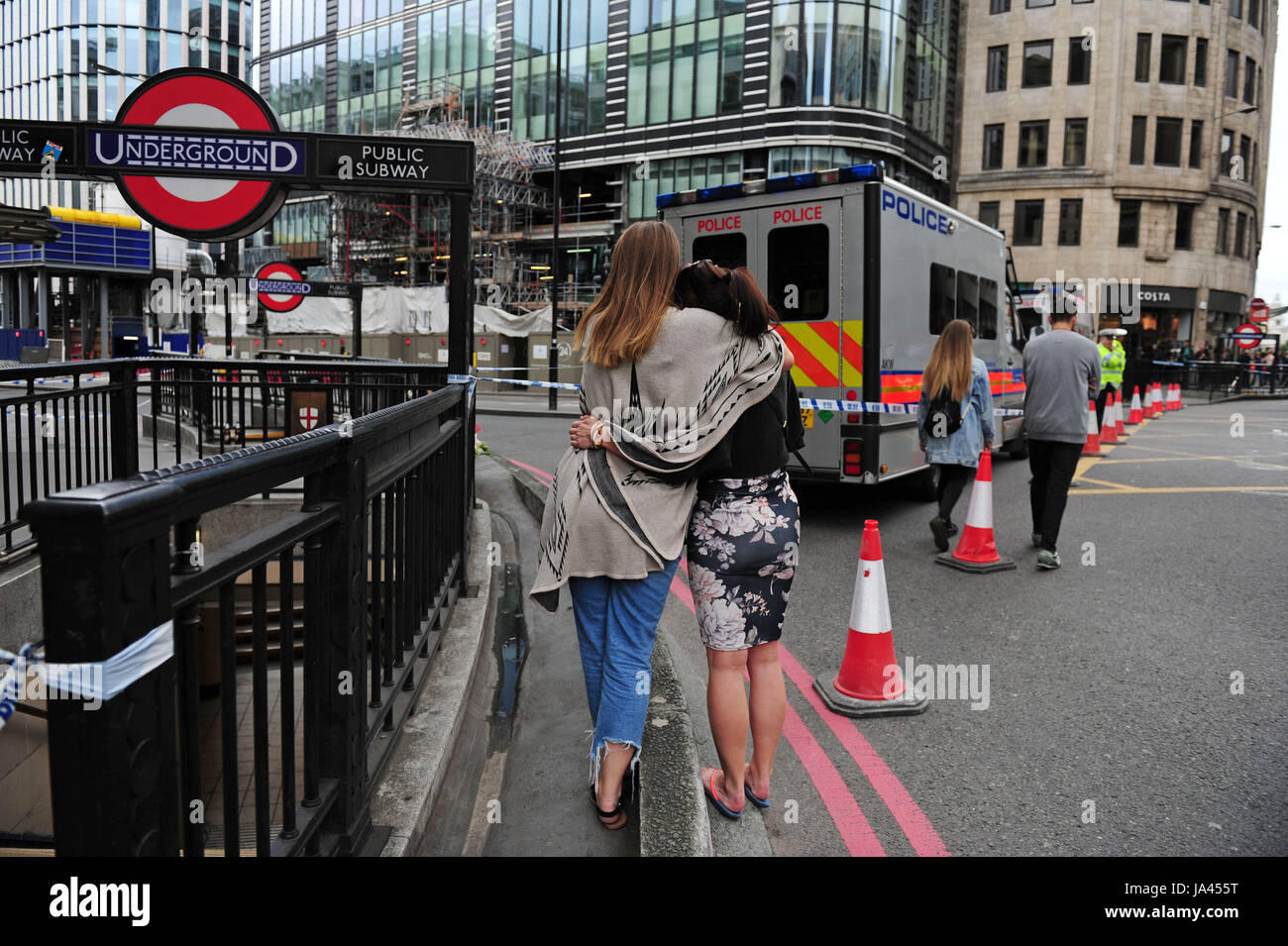 Zwei Frauen umarmen nach bringen Blumen hinzu Tribute legte auf der Nordseite der London Bridge nach gestern Abend terroristischen Anschlags. Stockfoto