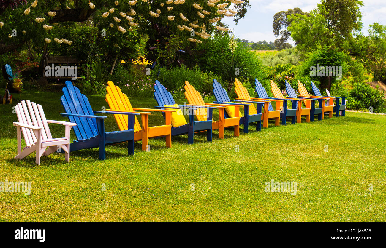 Reihe von bunten Liegestühlen auf Rasen Stockfoto