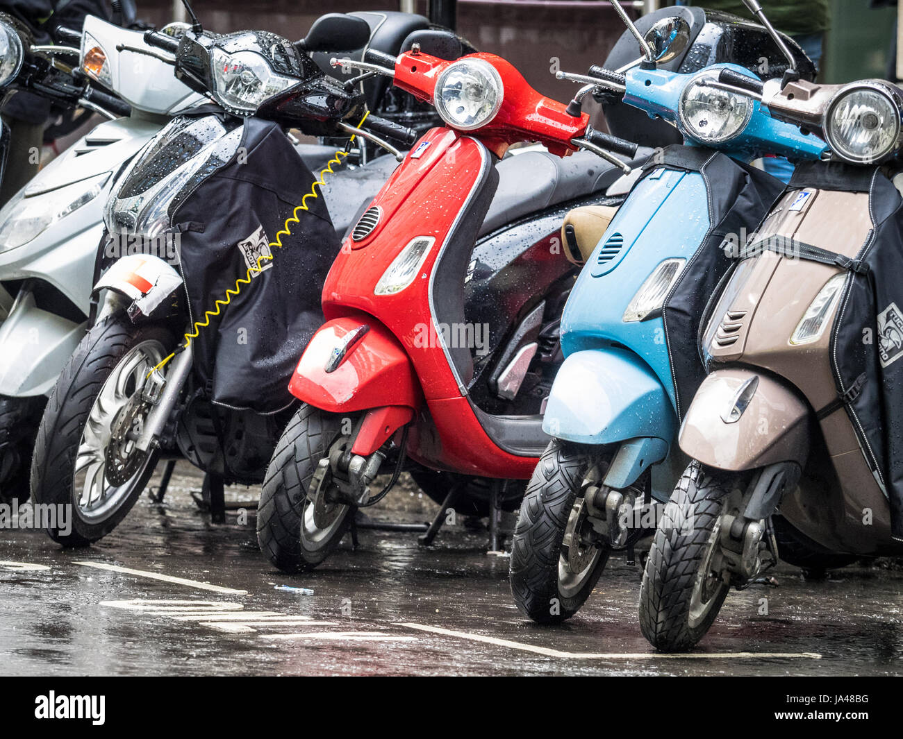 Pendler-Roller sind im Zentrum von London an einem regnerischen Tag geparkt. Stockfoto