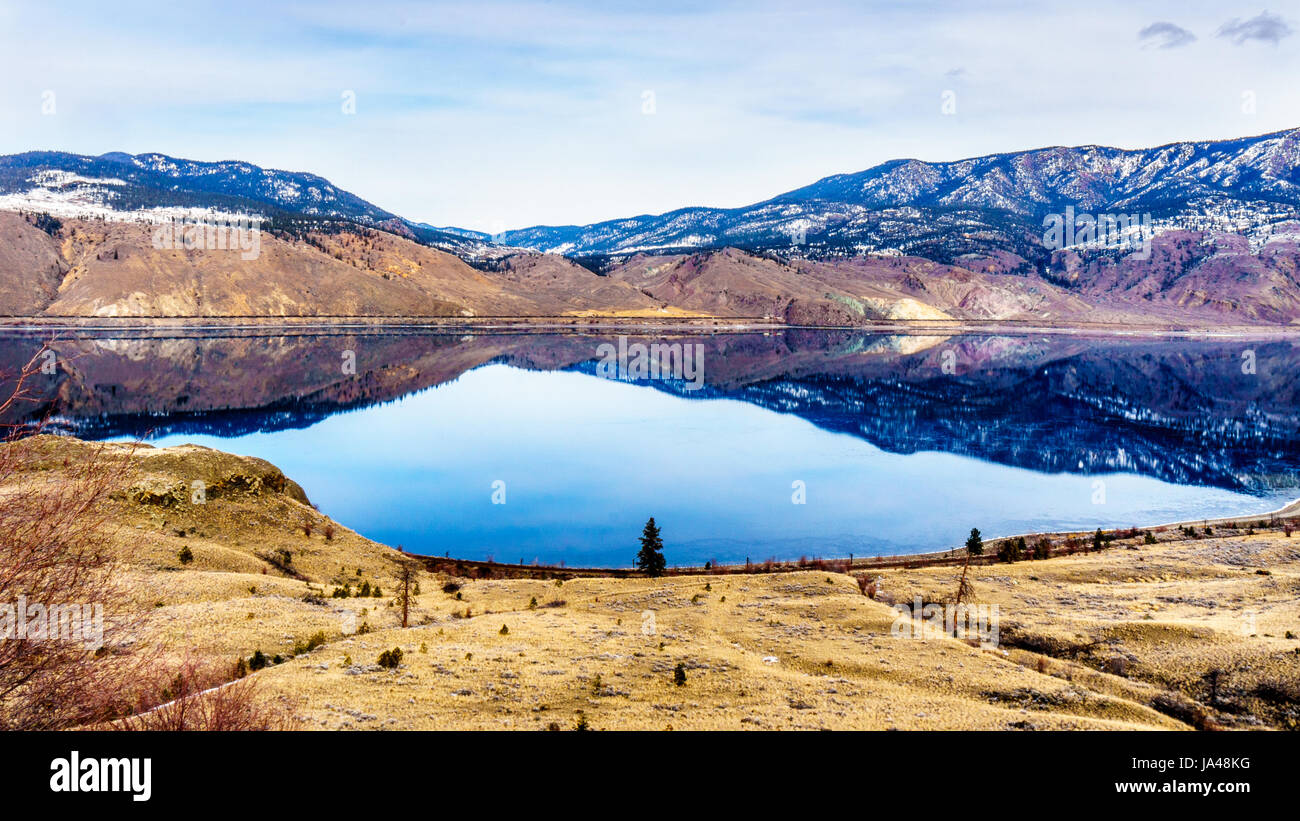 Kamloops Lake in British Columbia, Kanada, das ist ein breiter Teil der Thompson River, an einem kalten Wintertag mit der umliegenden Berge im Wasser widerspiegelt Stockfoto
