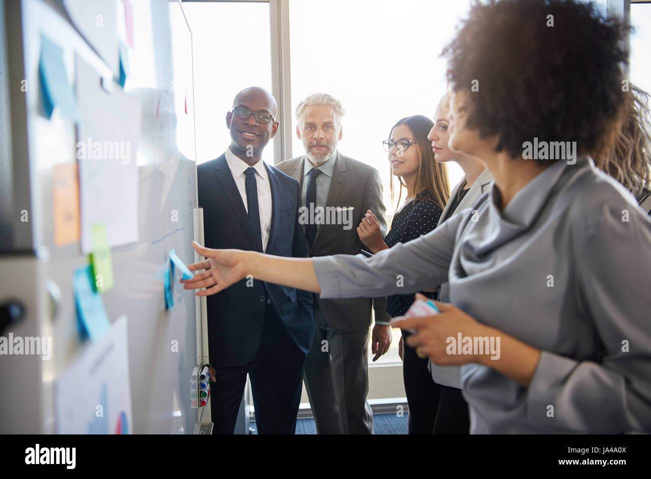 Gruppe von gemischten Geschäftsleute mit einem Treffen mit einer weißen Tafel in hellen Büroflächen Stockfoto