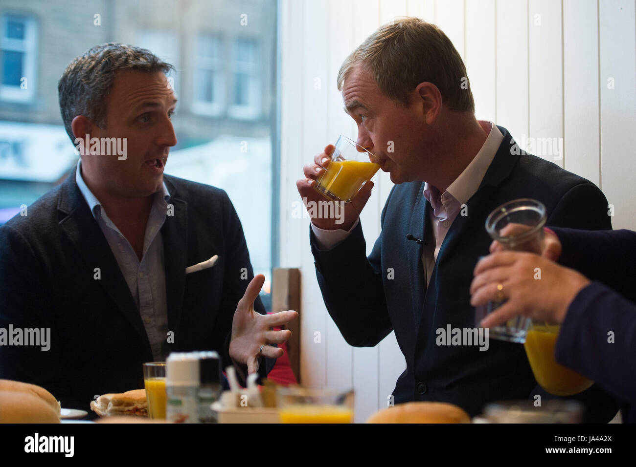 Liberal Democrats Leiter Tim Farron mit Alex Cole-Hamilton MSP nach Sandwiches für die Wähler während eines Besuchs in Cafe Vigo in Edinburgh im allgemeinen Wahlen Wahlkampf zu machen. Stockfoto