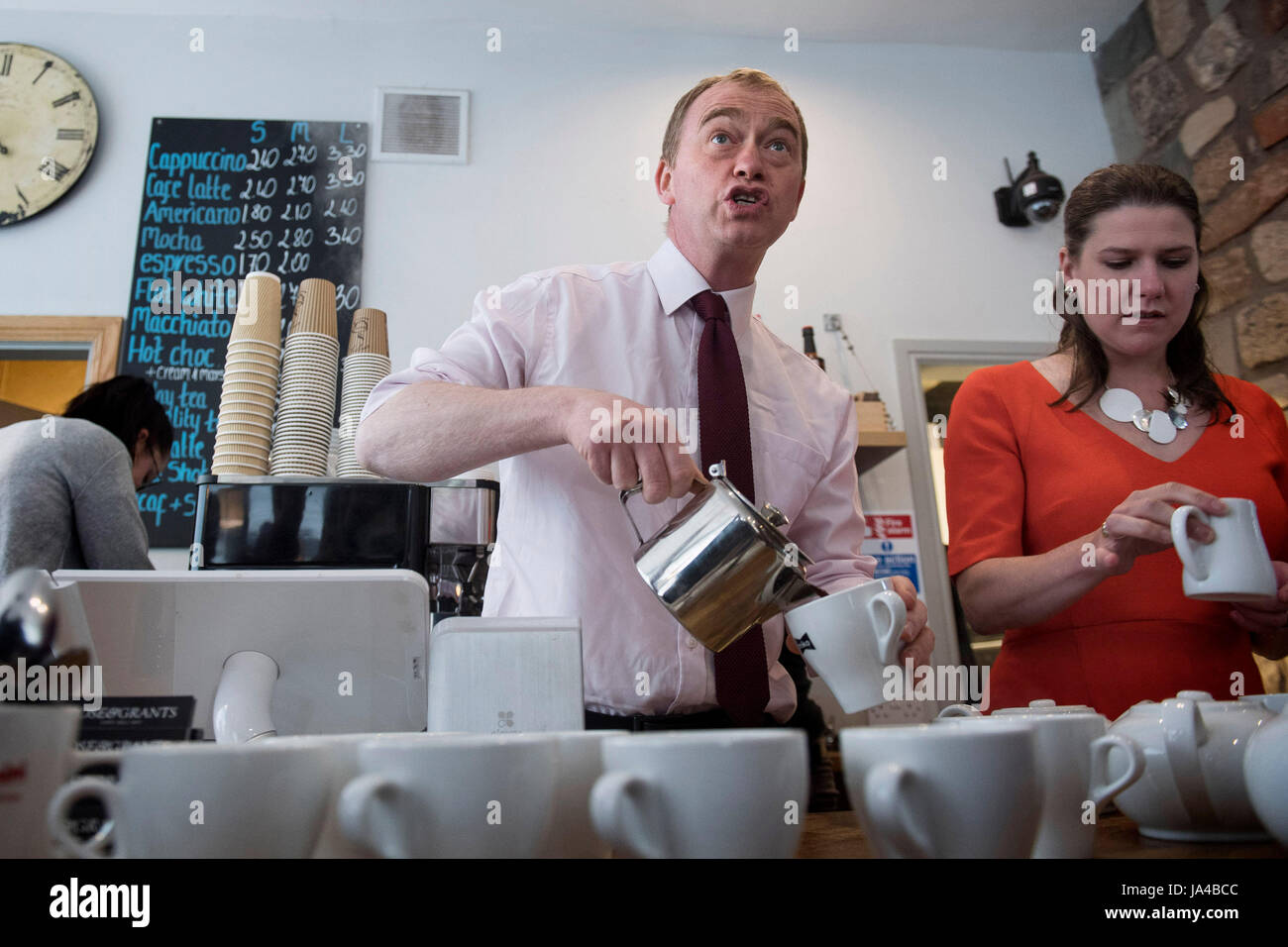 Liberal Democrats Führer Tim Farron und Jo Swinson, lokalen Kandidaten für East Dunbartonshire, machen Kaffee für Aktivisten im Rose und Zuschüsse Café in Glasgow im allgemeinen Wahlen Wahlkampf. Stockfoto