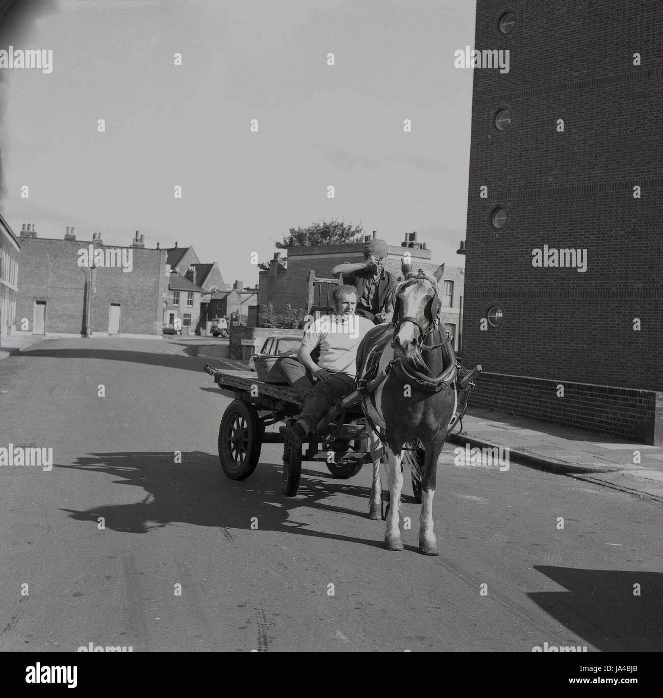 1971, historische, zwei männliche Totters oder Lappen und Knochen Männer auf ihr Pferd und Wagen in einer leeren Straße im Süden von London, als sie ihre Runden auf der Suche nach Metall und andere unerwünschte Gegenstände Schrott. Stockfoto