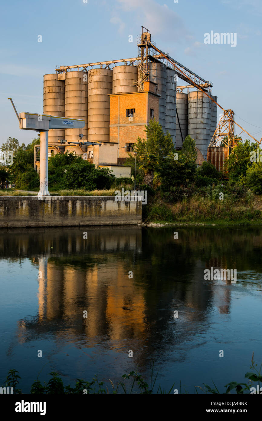 Alte Fabrik mit Silos und Reflexion auf dem Wasser Stockfoto