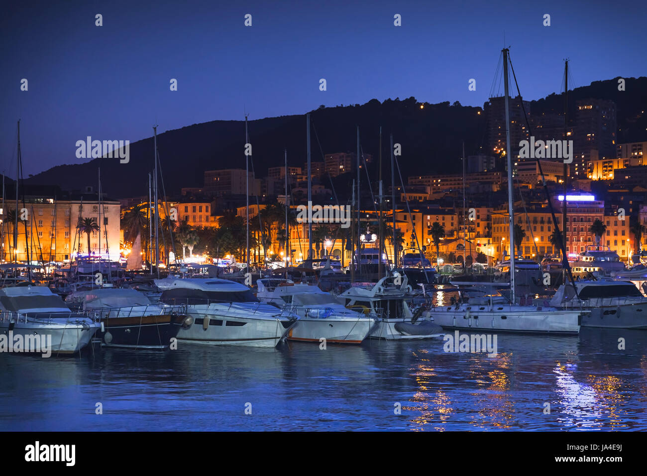 Sportboote und Motorboote vor Anker im alten Hafen von Ajaccio, Korsika, Frankreich. Dunkle Nacht Foto Stockfoto