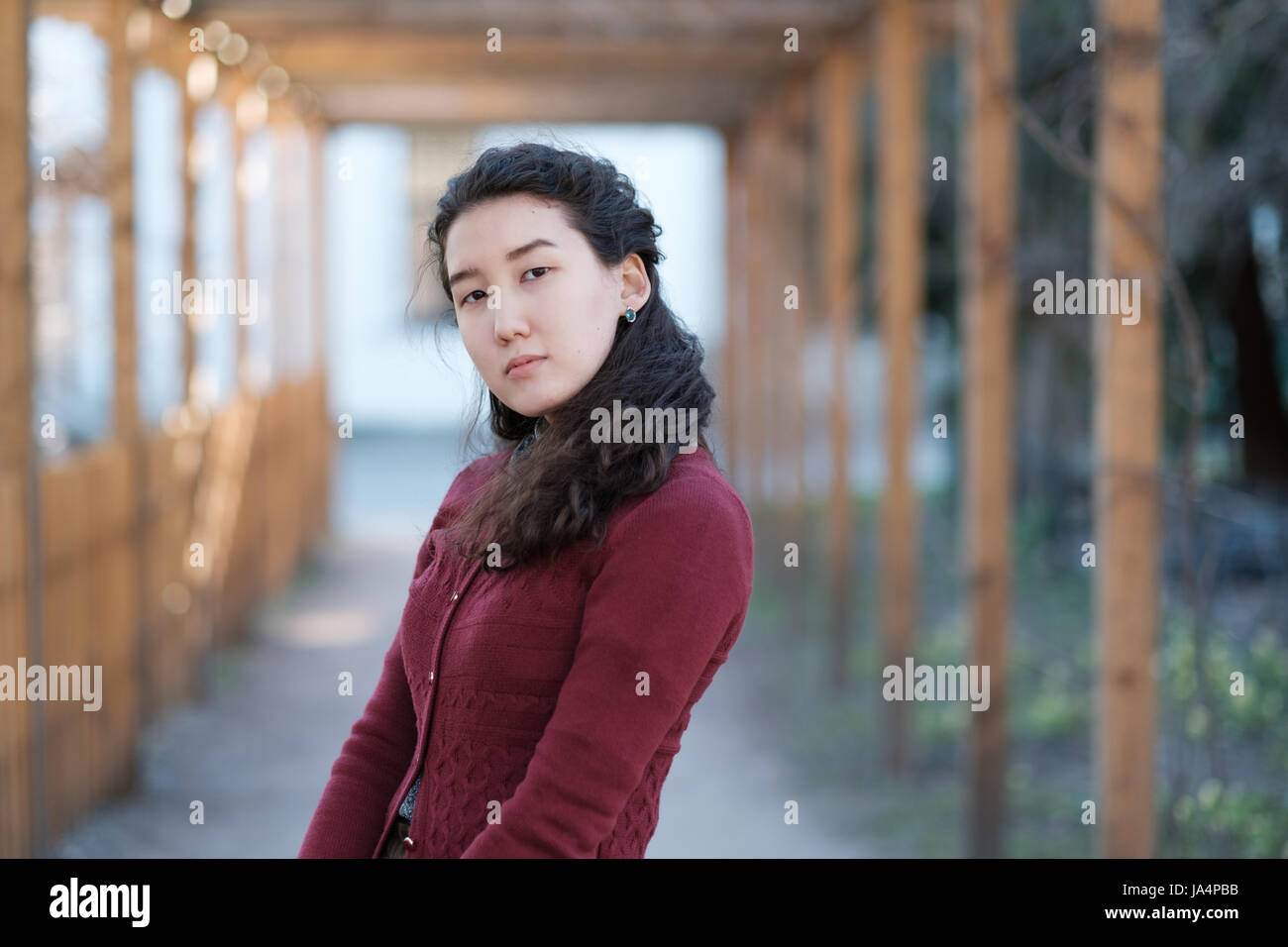 Eine schöne Asiatin steht in bescheidenen Kleidung in der Mitte eine Gasse im park Stockfoto