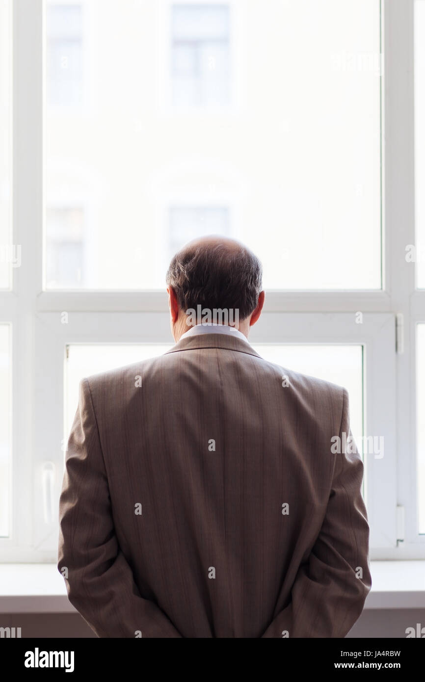 Porträt eines Mannes im Anzug am Fenster. Snapshot von der Rückseite Stockfoto