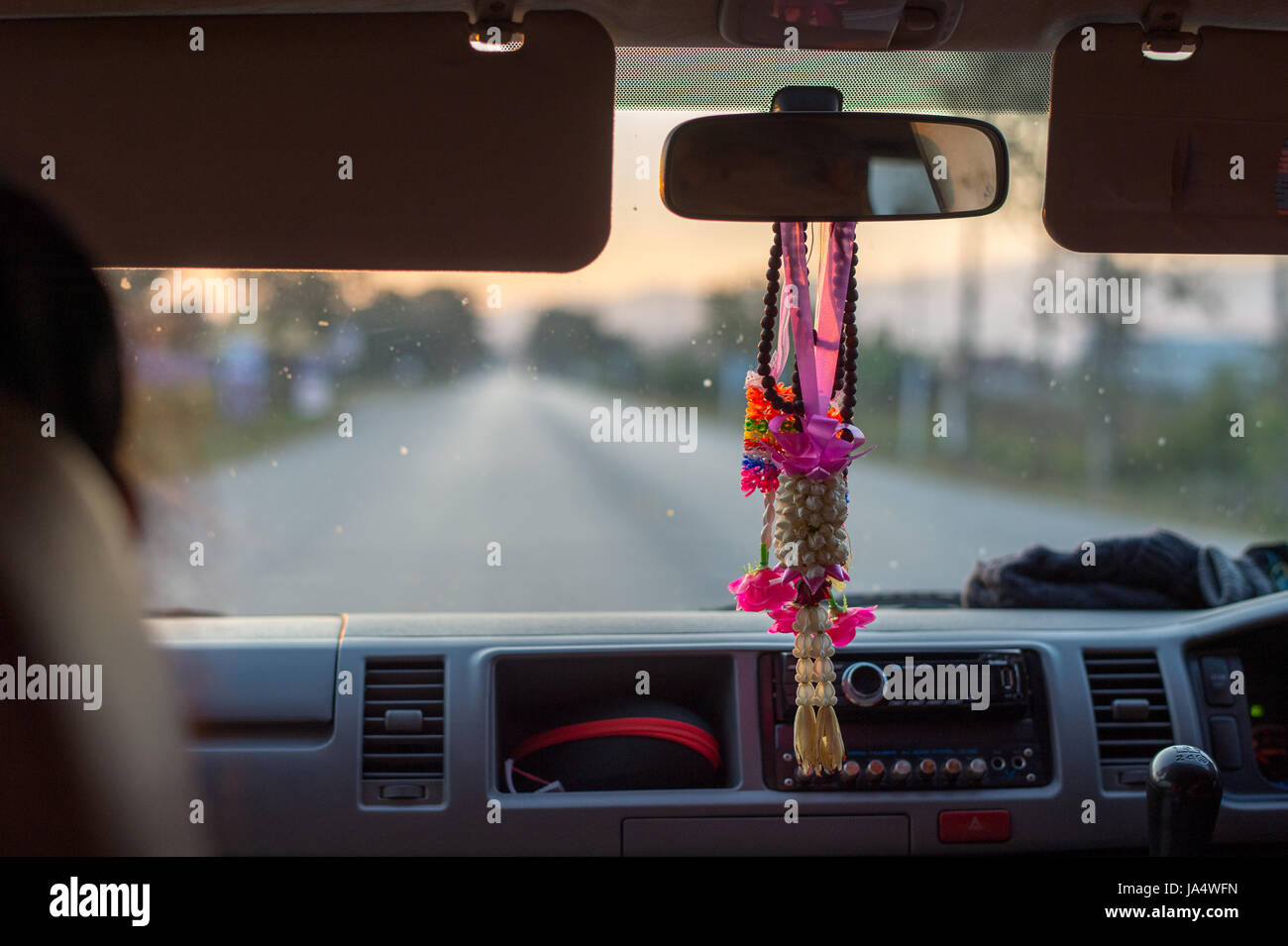Ein alltäglicher Anblick in Thailand. Phuang Malai - eine Blumengirlande verkauft für Glück hängen nach unten aus dem Rückspiegel in einem Taxi. Stockfoto