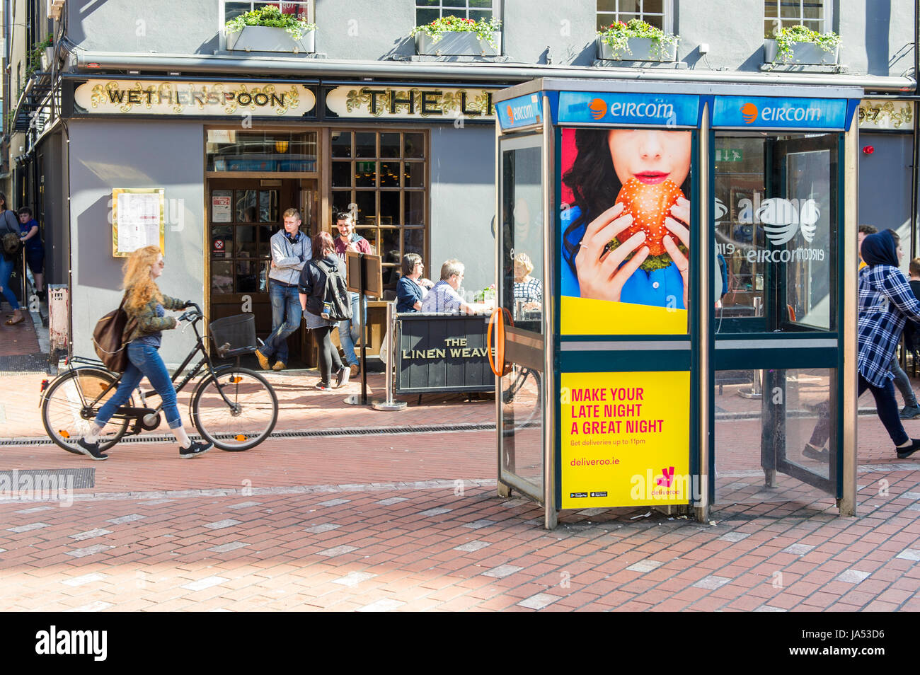 Deliveroo Anzeige auf ein öffentliches Telefon Telefonzelle in Cork, Irland mit Menschen oder Ehrenbreitstein Pub. Stockfoto