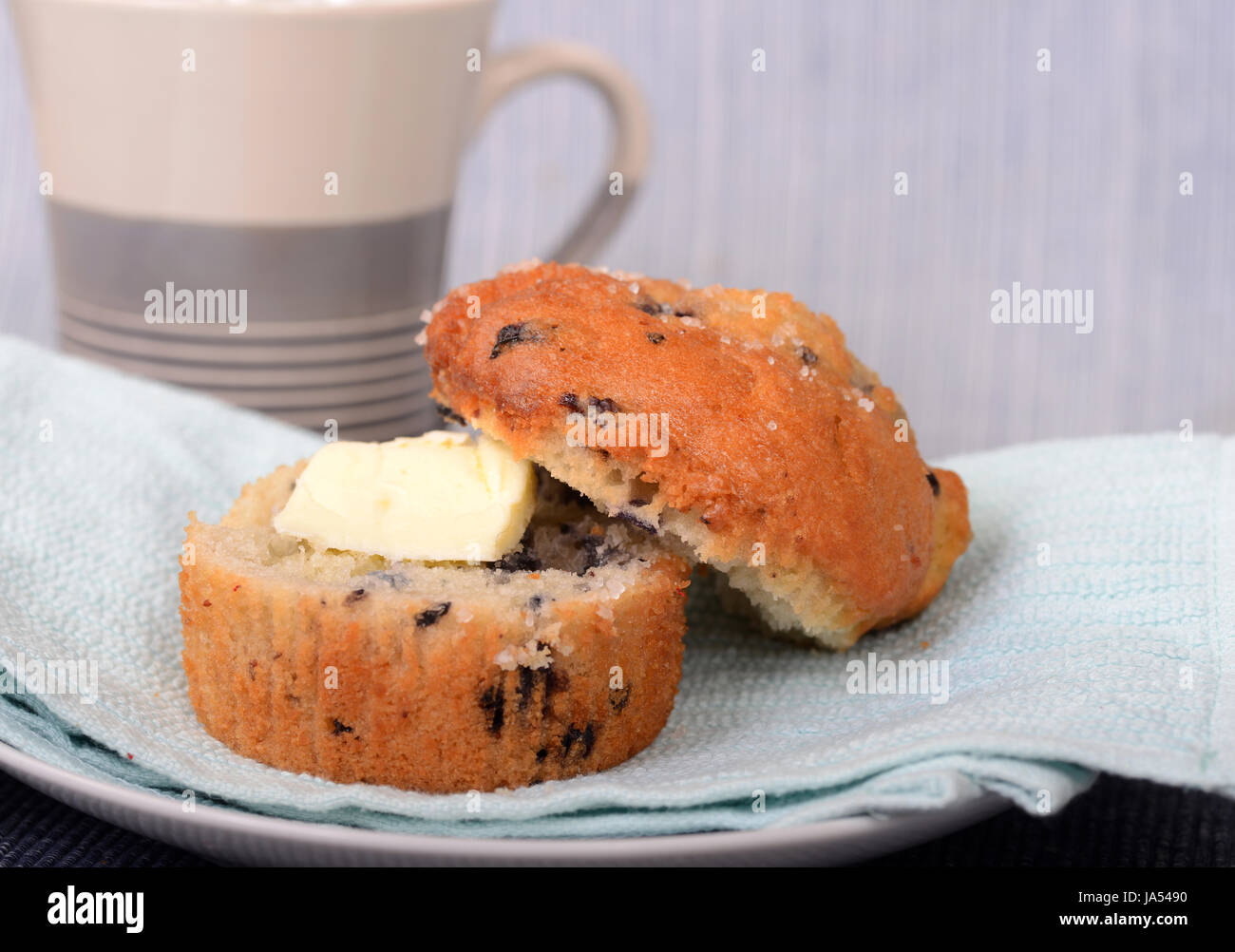 Köstliche warme Blueberry Muffin, serviert mit Butter und eine Tasse Kaffee Stockfoto