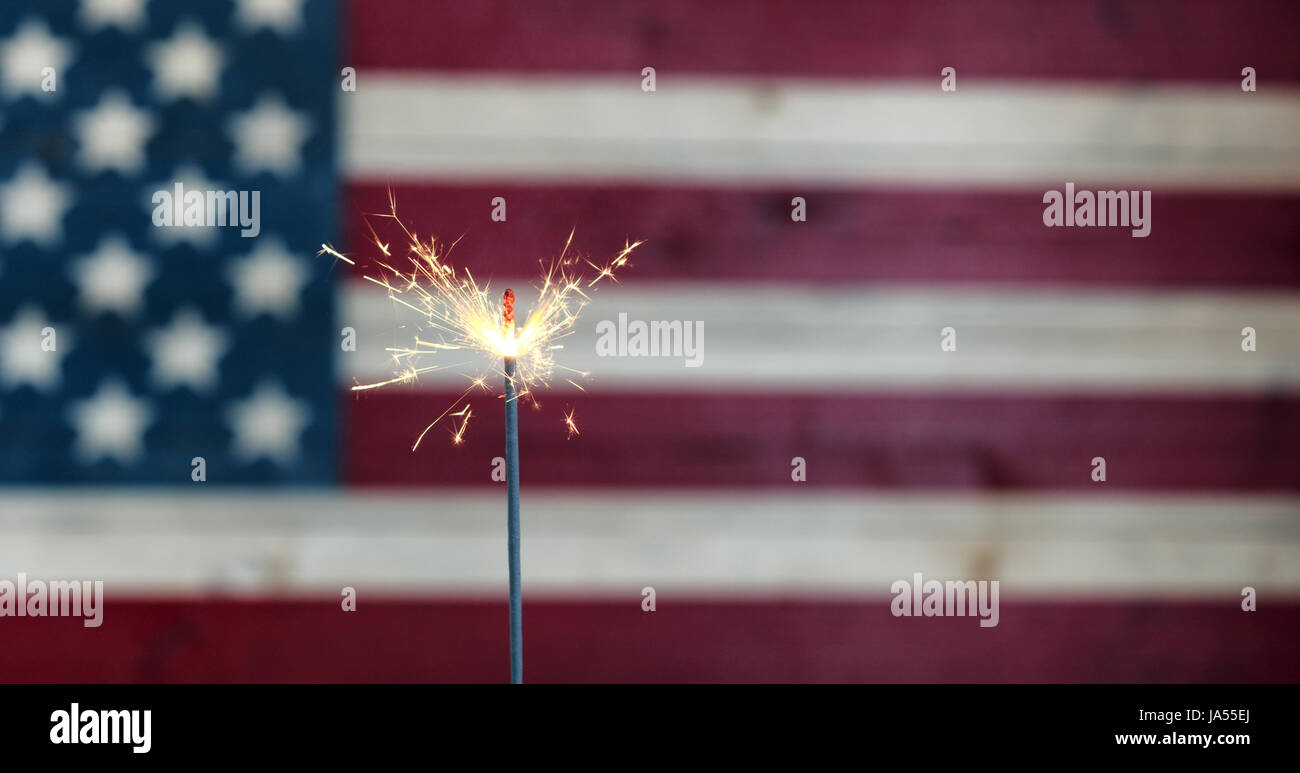 Brennende Wunderkerze mit rustikalen hölzernen USA Flagge im Hintergrund Stockfoto
