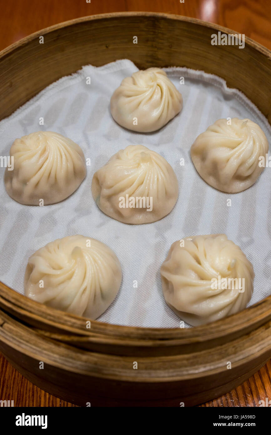 Vertikale Nahaufnahme von Xiao Long Bao in einem Bambus-Dampfer. Stockfoto