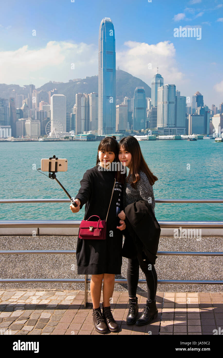 Vertikale Porträt von Touristen unter Selfies auf die dramatische Skyline von Hong Kong Island, China. Stockfoto