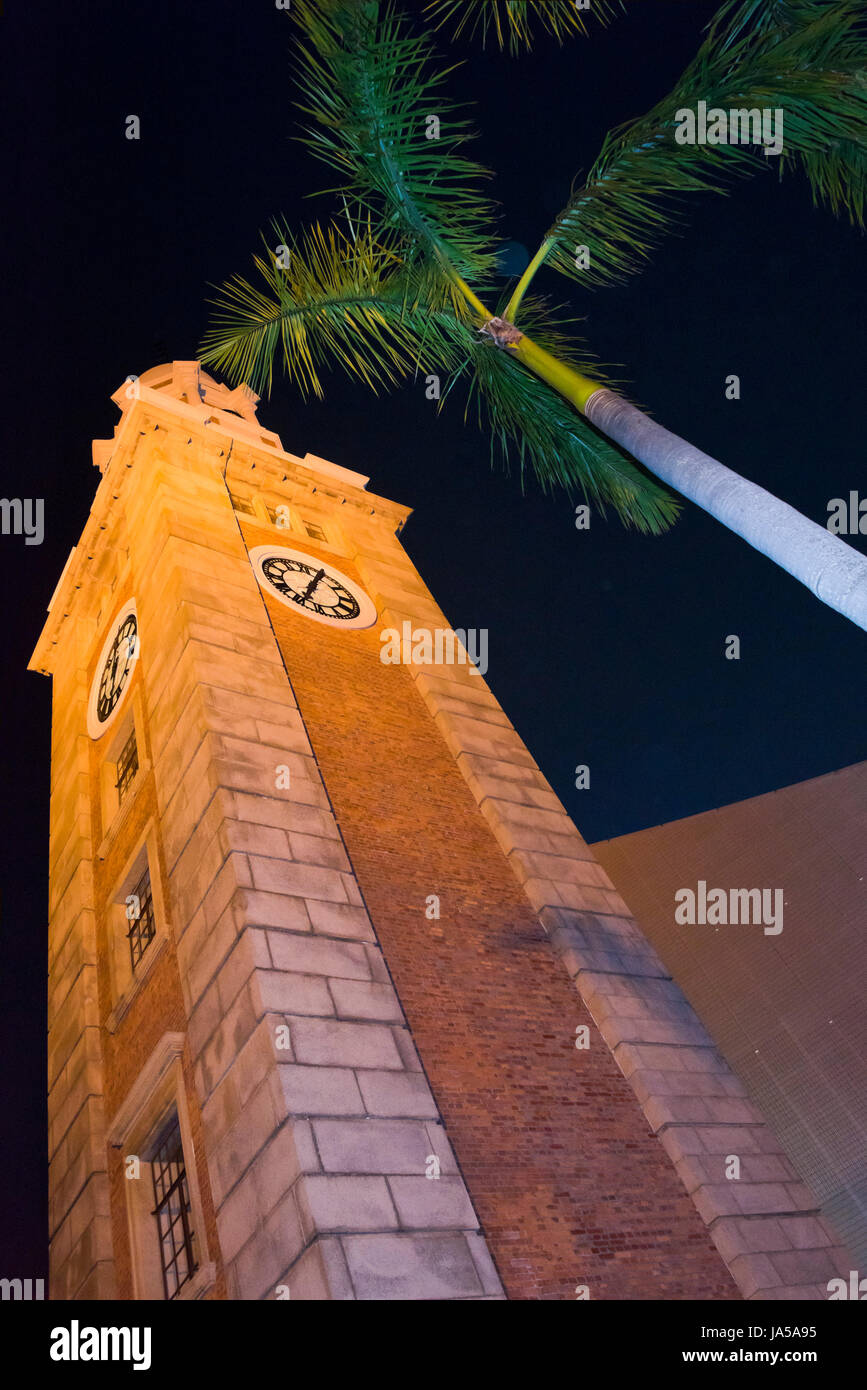 Vertikale Ansicht auf den berühmten Uhrturm in Tsim Sha Tsui, Hongkong, beleuchtet nachts. Stockfoto