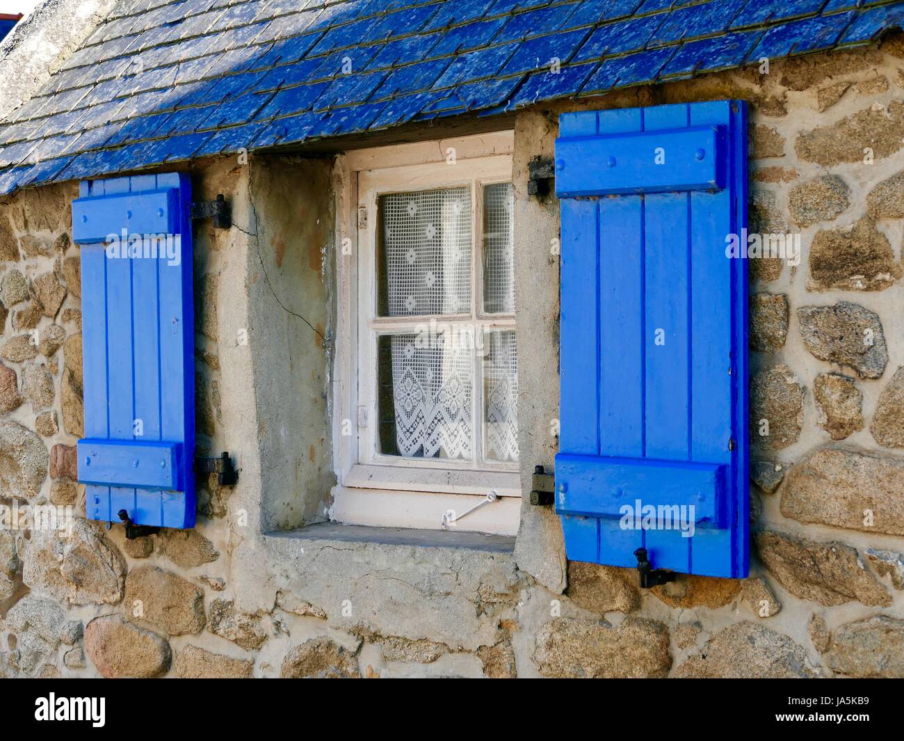 Ferienhaus-Fenster, kleine, weiße Rahmen trimmen, blaue Fensterläden, Steinmauern, Île de Batz, Frankreich Stockfoto