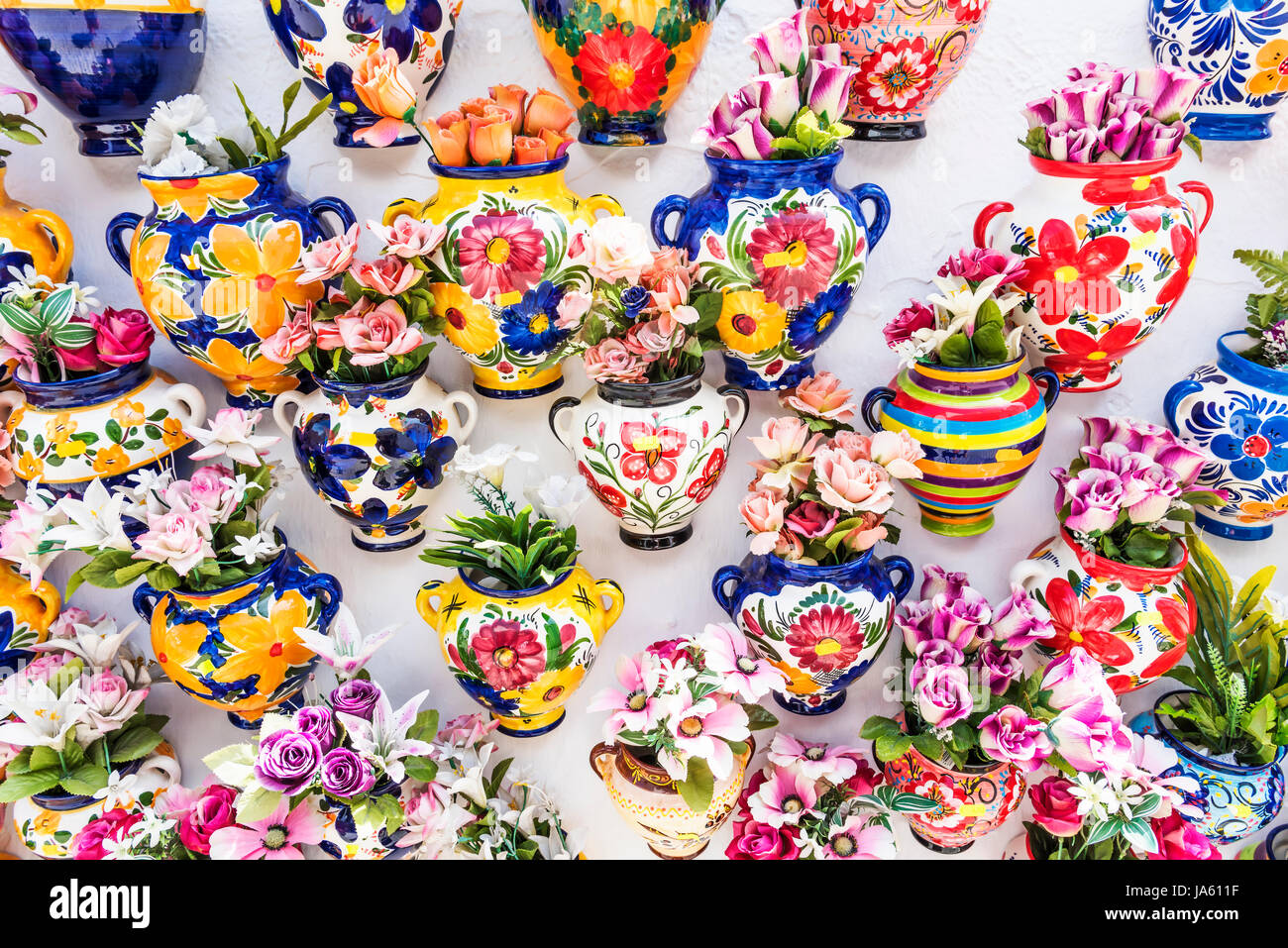 Bunte Keramik-Vasen mit Blumen auf einer Shop-Wand in Mijas, Andalusien, Spanien, Europa Stockfoto