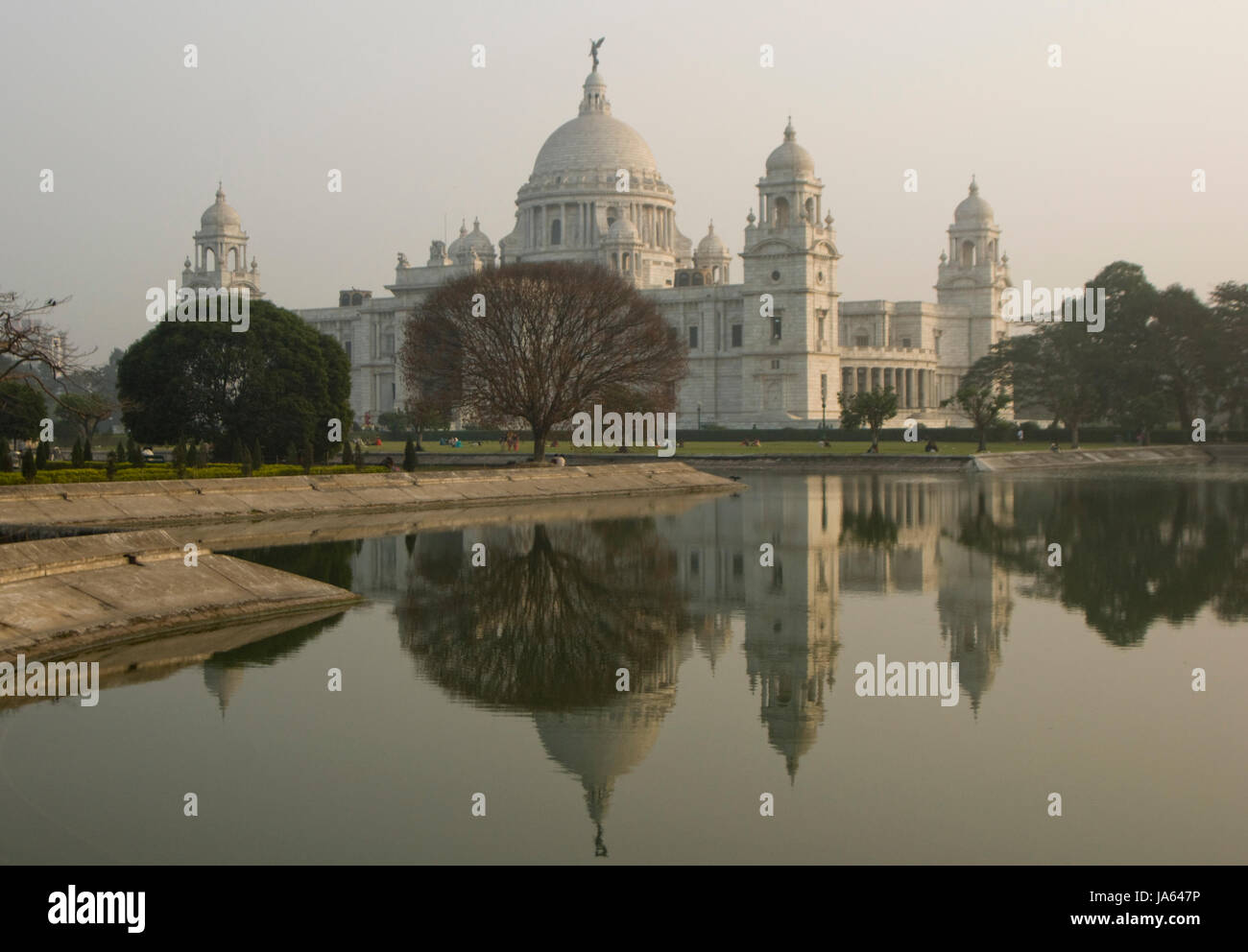 Victoria Denkmal in Kalkutta, Westbengalen, Indien. Reich verzierte weißes marmornes Gebäude spiegelt sich in einem Zierteich in der Abenddämmerung Stockfoto