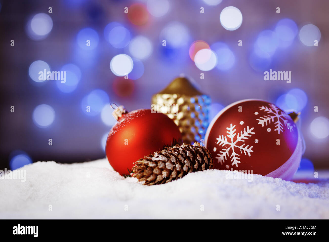 Verzierten Weihnachtskugeln im Schnee mit blauer Hintergrundbeleuchtung. Stockfoto