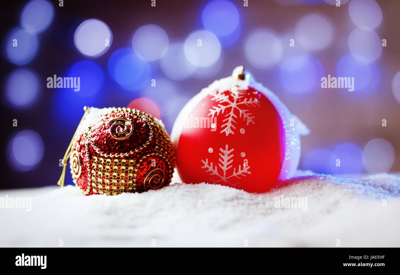 Verzierten Weihnachtskugeln im Schnee mit blauer Hintergrundbeleuchtung. Stockfoto