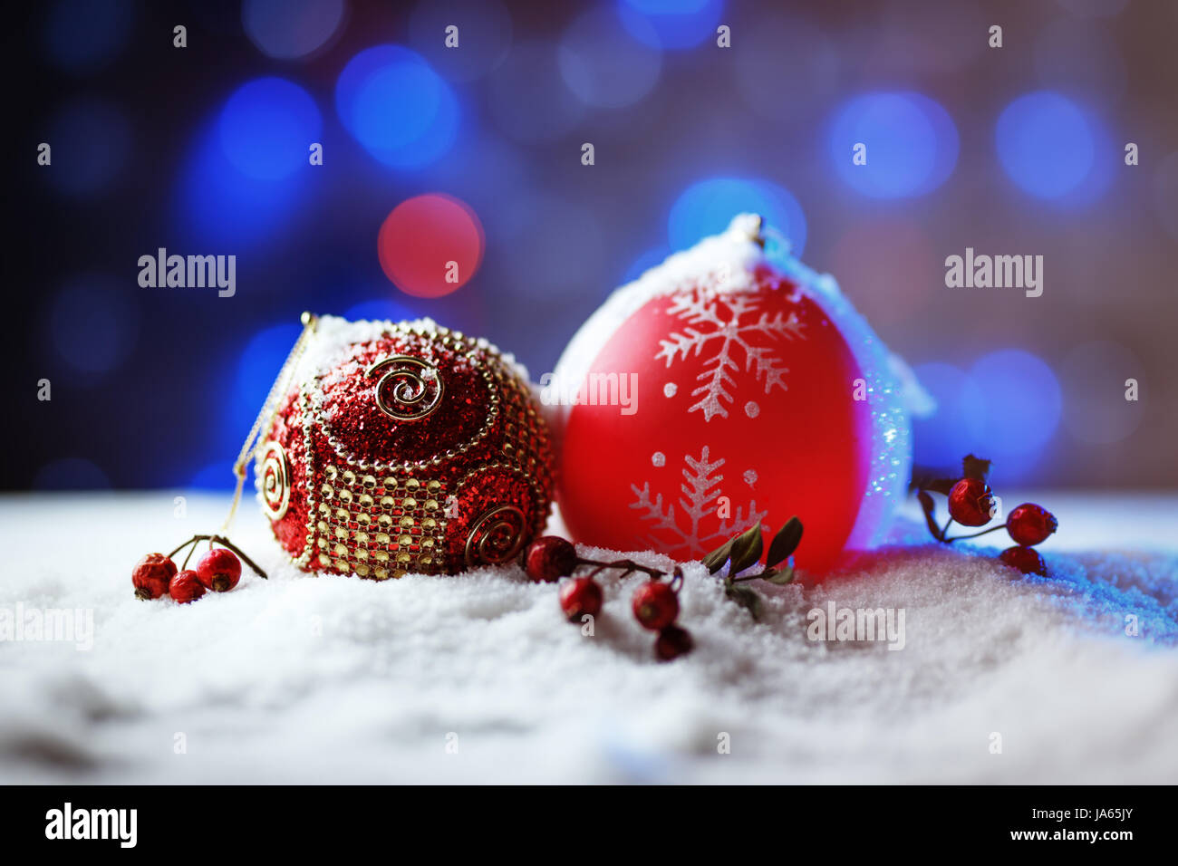 Verzierten Weihnachtskugeln im Schnee mit blauer Hintergrundbeleuchtung. Stockfoto