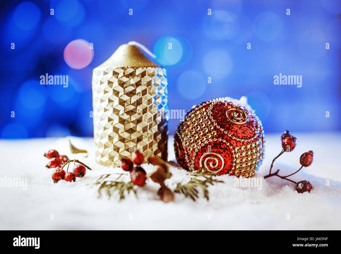 Kerze und Weihnachten Dekoration im Schnee mit blauem Licht Hintergrund. Stockfoto