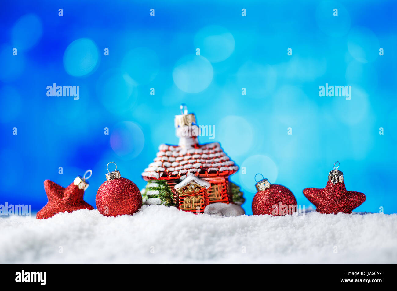 Weihnachtsschmuck im Schnee mit blauer Hintergrundbeleuchtung. Stockfoto