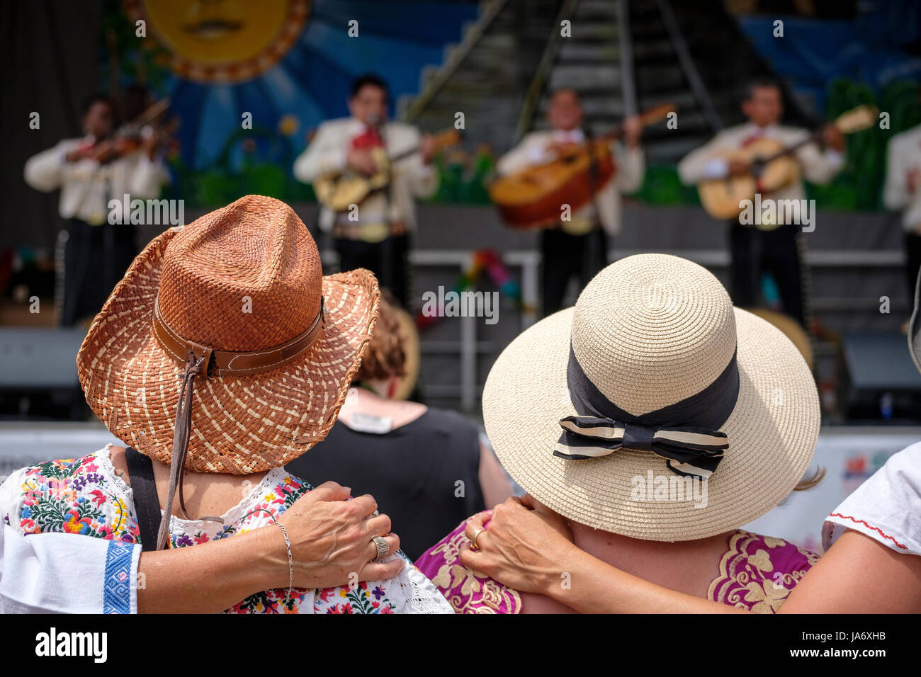 London, Ontario, Kanada. 4.. Juni 2017. Fiesta London! Mexikanisches Festival, das die Klänge, die Kultur und das Essen Mexikos auf dem Covent Garden Market in der Innenstadt von London, Ontario, feiert. Das jährlich stattfindende Festival bringt eine Vielzahl von Künstlern, farbenfrohen folkloristischen Tänzern, Sängern und Unterhaltung aus ganz Lateinamerika zusammen. Eine Gruppe von Freunden, die Strohhüte tragen, umarmen sich mit dem Rücken zur Kamera, tanzen und hören der Konzertmusik zu und haben eine tolle Zeit zusammen. Kredit: Rubens Alarcon/Alamy Live Nachrichten Stockfoto