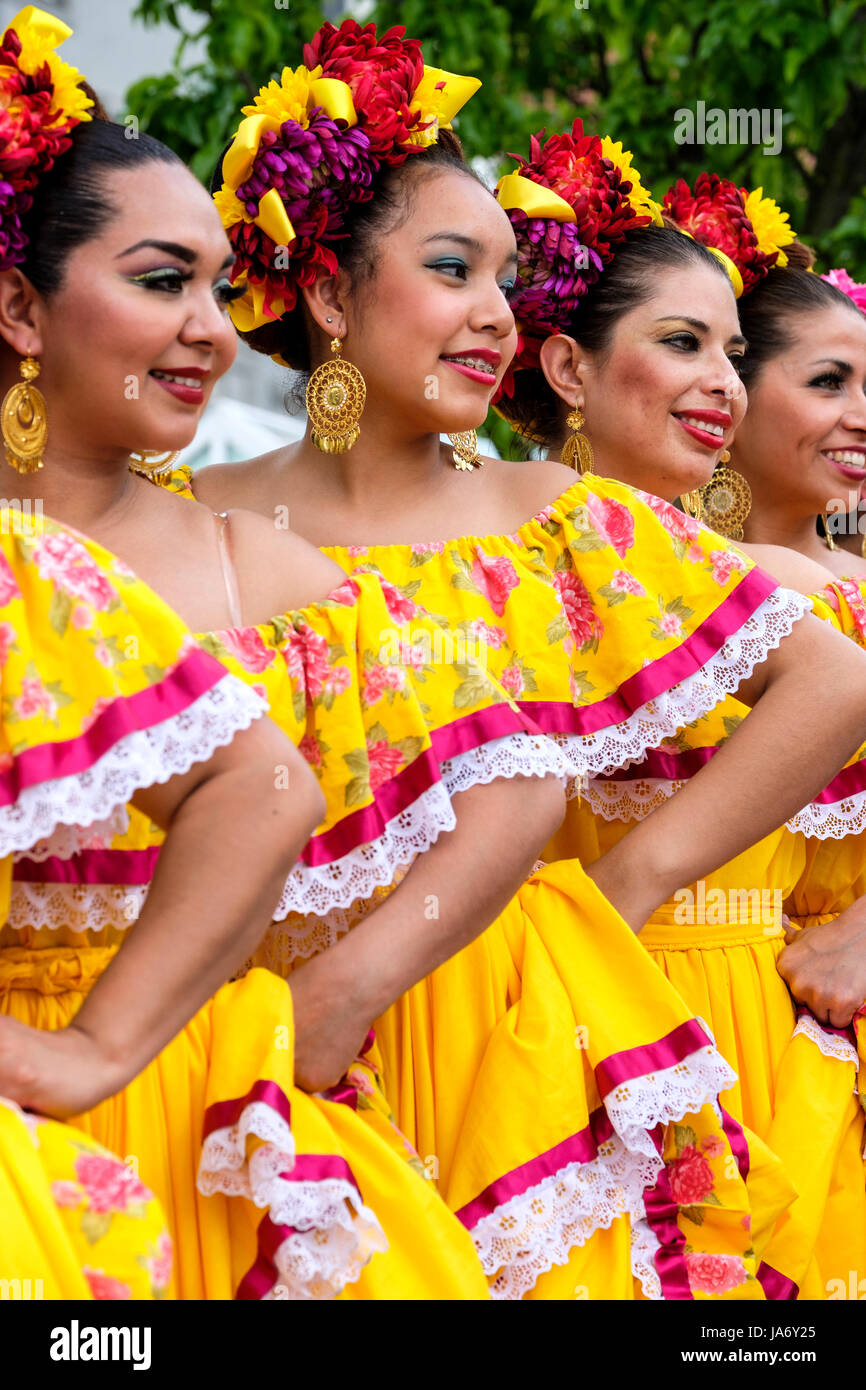 Eine Gruppe mexikanischer Mariachi-Tänzerinnen, die mexikanische traditionelle sinaloa-Kleider tragen, gelbe Kleider tragen, Mexikos kulturelles Erbe feiern, Folkloretanz, Gruppenfoto, Seitenansicht. Stockfoto