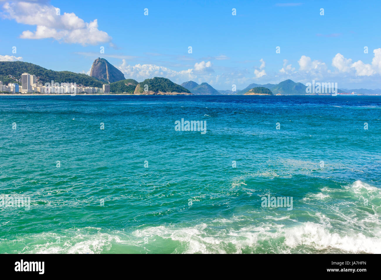 Copacabana Strand in Rio De Janeiro mit seinen Gebäuden, Meer, Sand und den Zuckerhut im Hintergrund Stockfoto