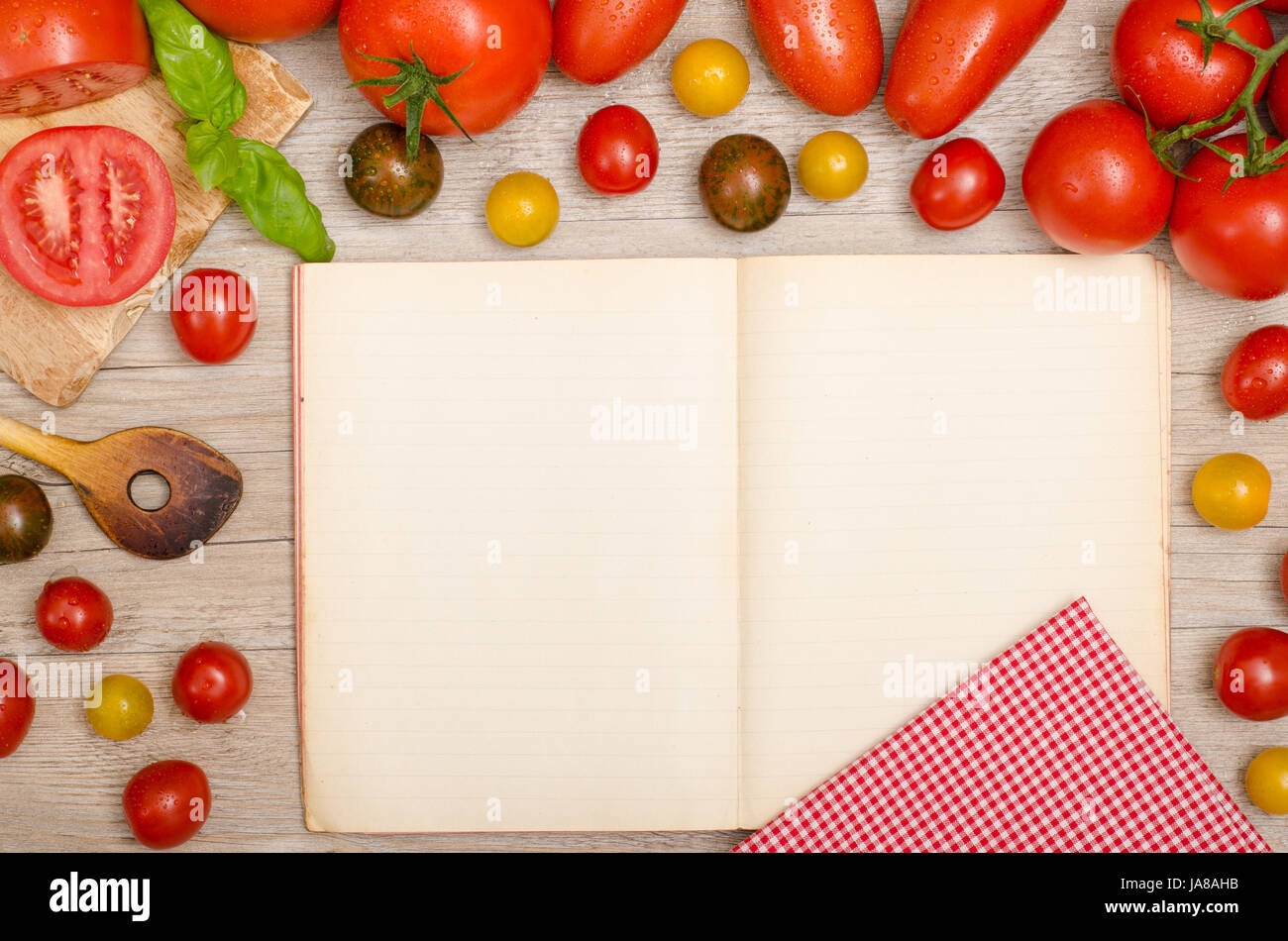 verschiedene Arten von Tomaten, Basilikum, Koch-Löffel und Deckel mit Textfreiraum Stockfoto