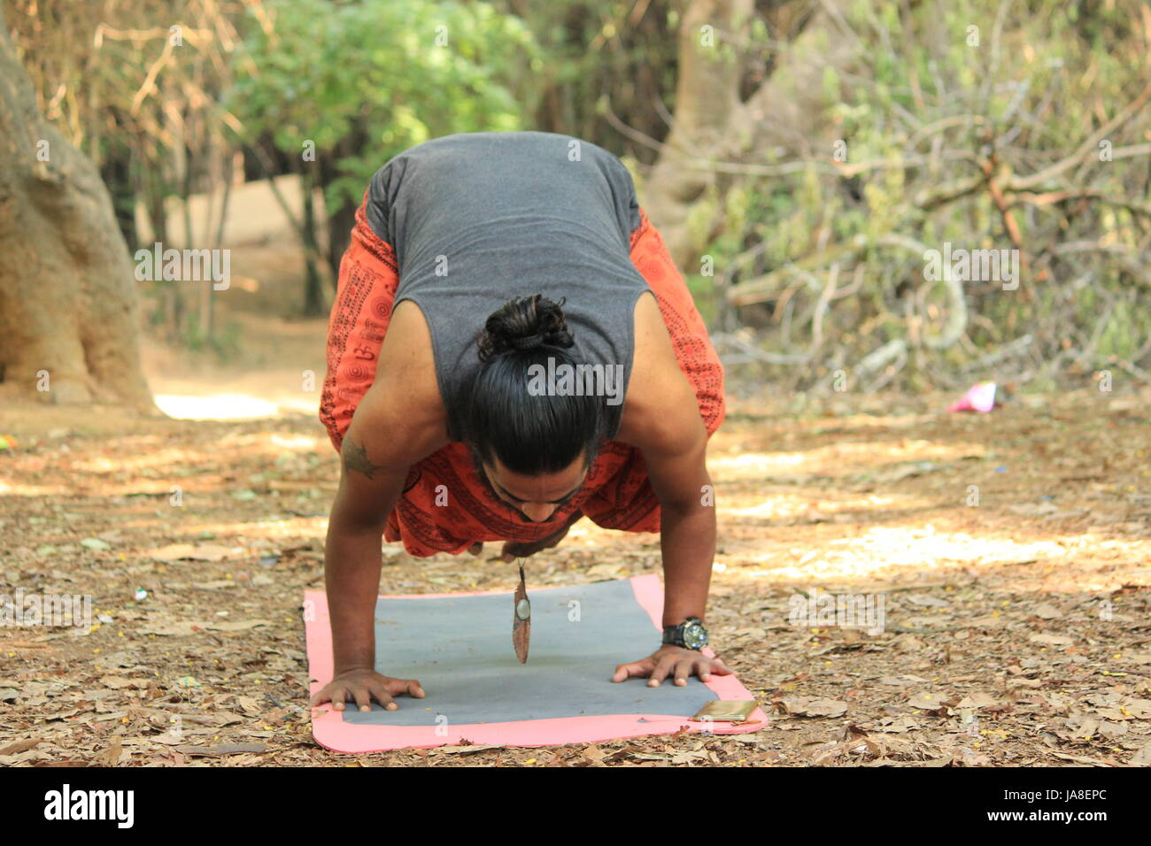 Indischen Jüngling die Krähe Pose durchführen. (Bakasana) Lage - Cubbon Park, Bangalore. Stockfoto