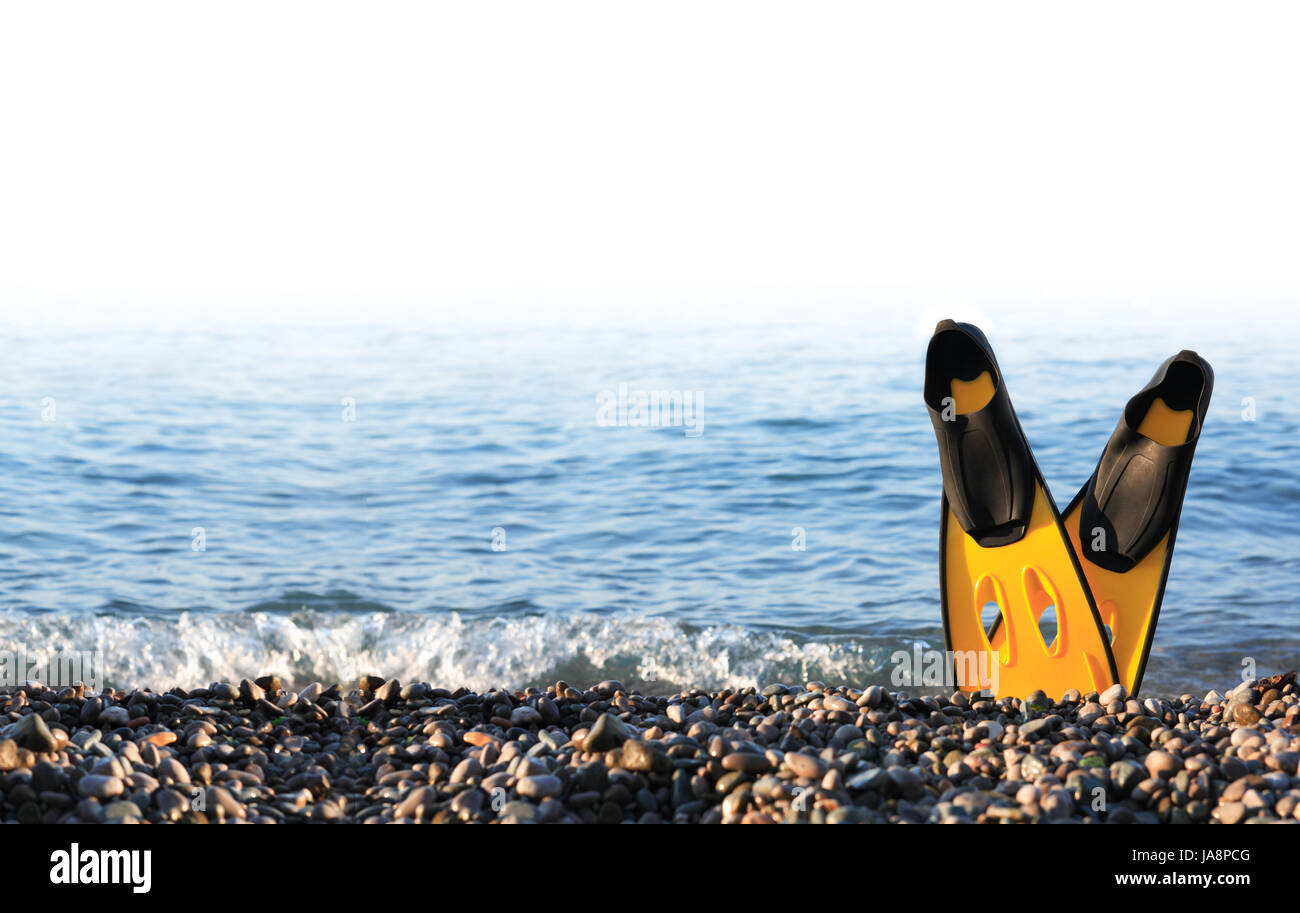 Tauchen-Konzept. Paar von gelben Flossen am Meeresstrand gegen Meer stehend Stockfoto