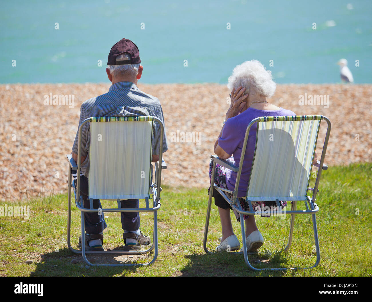 Älteres Paar am Strand sitzen. Stockfoto
