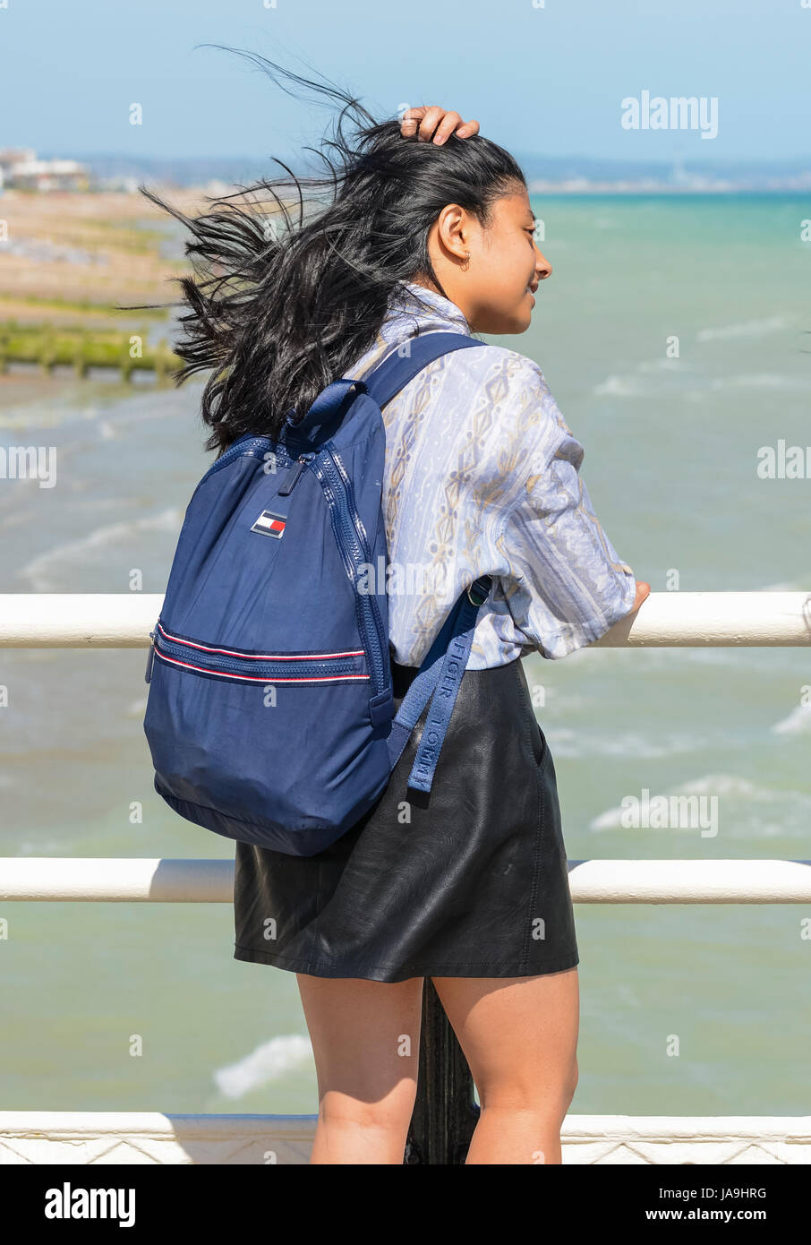 Asiatische Teenagerin im Blick auf das Meer von einem Pier Wind stehen. Stockfoto