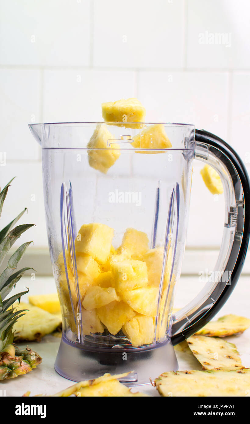 Ananasscheiben in Blender für einen Smoothie fallen Stockfoto
