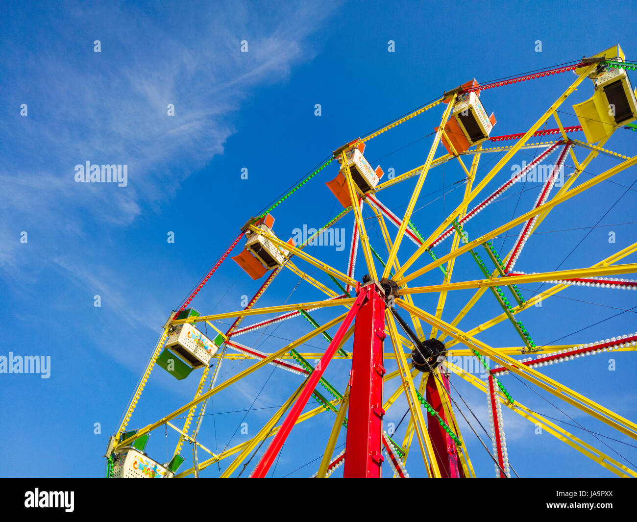 Ein Riesenrad Jahrmarkt vor blauem Himmel. Stockfoto