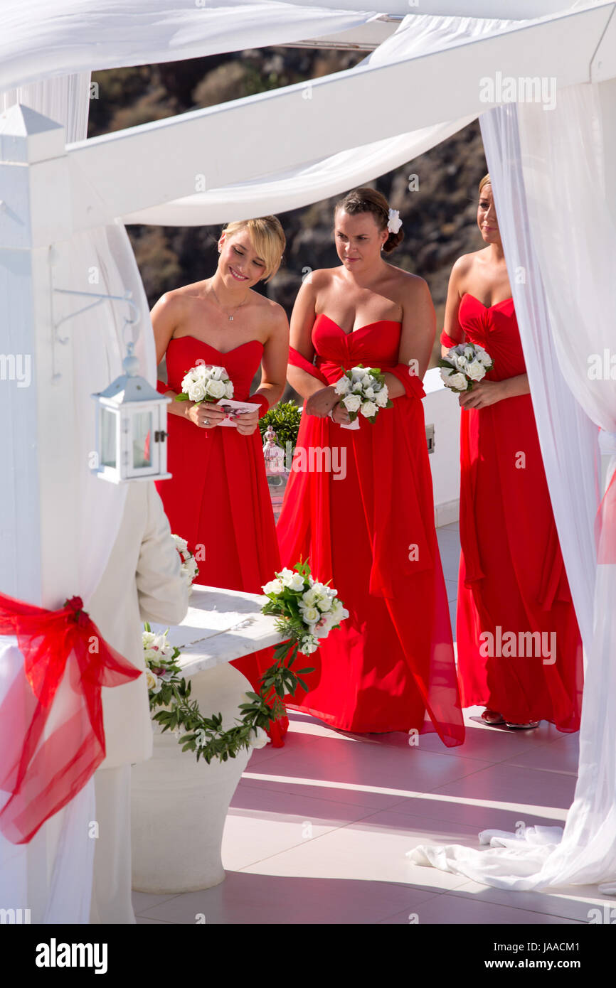 Santorin, Griechenland, Juni 25: Unidentified Brautjungfern auf einer Hochzeit tragen schöne rote Kleider und weißen Blüten, Griechenland 2013. Stockfoto
