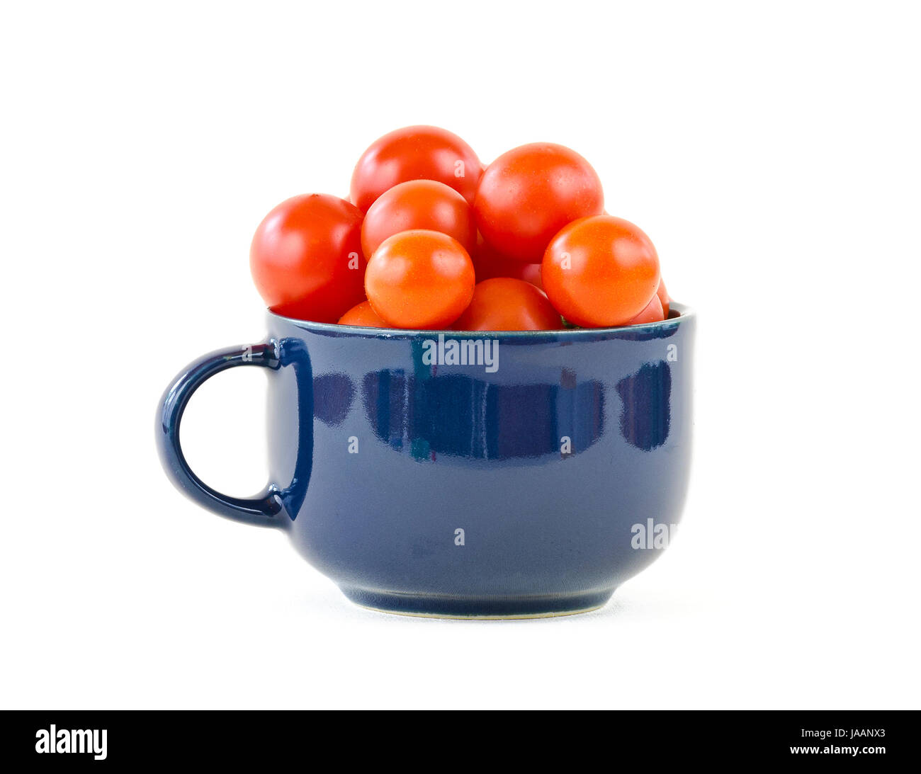 Rote Cocktailtomaten in Blauer Tasse Mit Henkel; roten Cocktailtomaten in einer blauen Tasse mit Griff Stockfoto