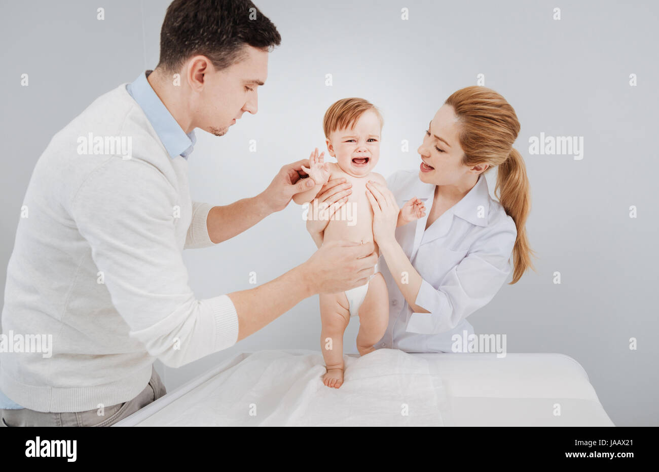 Kein Problem. Angst, emotionale schreiendes Kind scheinbar Angst vor seinem Arzt, während sie versuchen, sich vor Beginn einer Prüfung vorstellen Stockfoto