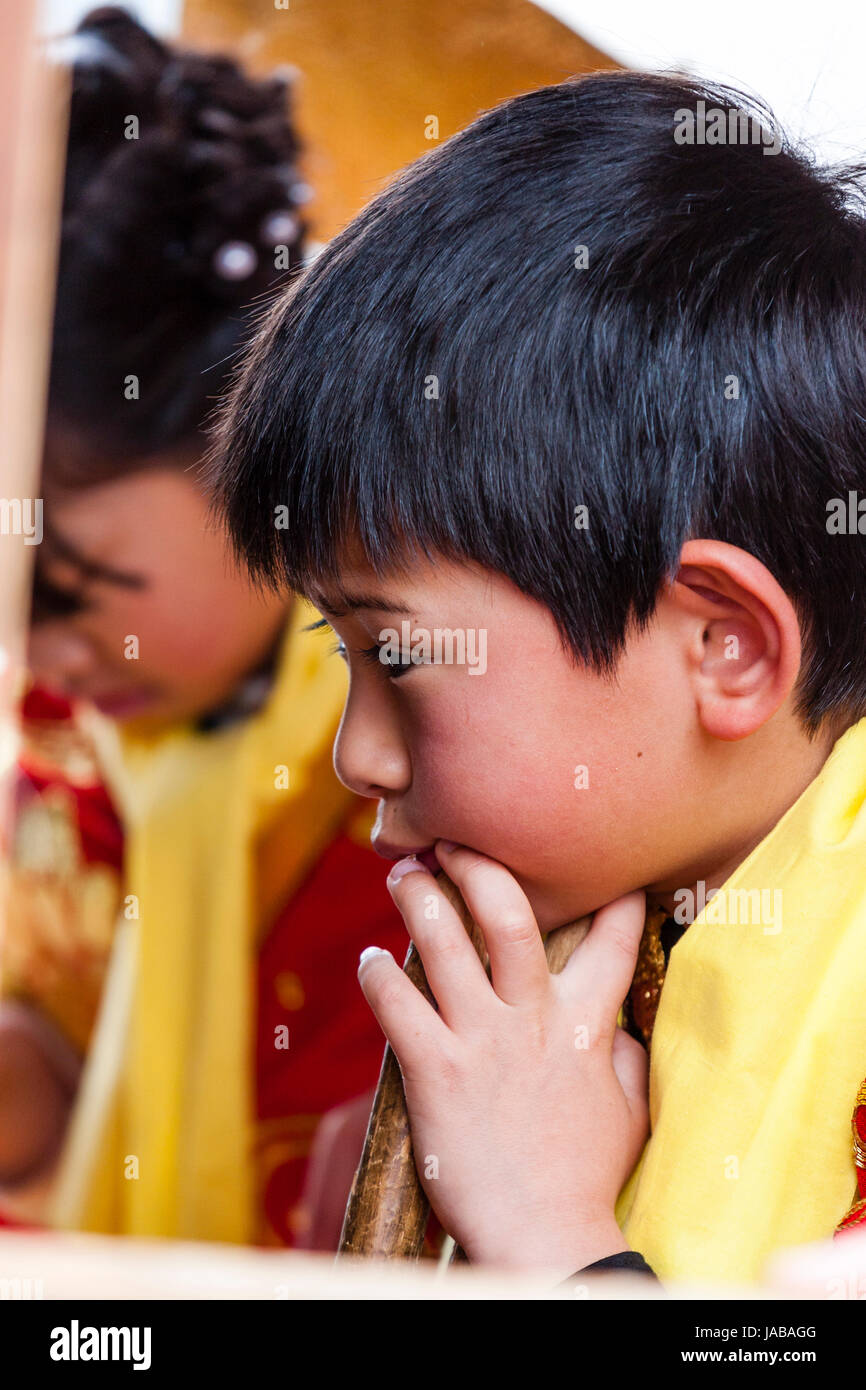 Japanisch, asiatische Kind, Junge, 5-6 Jahre alt, Seitenansicht Kopf und Schultern, Händen unter dem Kinn und schaute nachdenklich und besorgt. Stockfoto